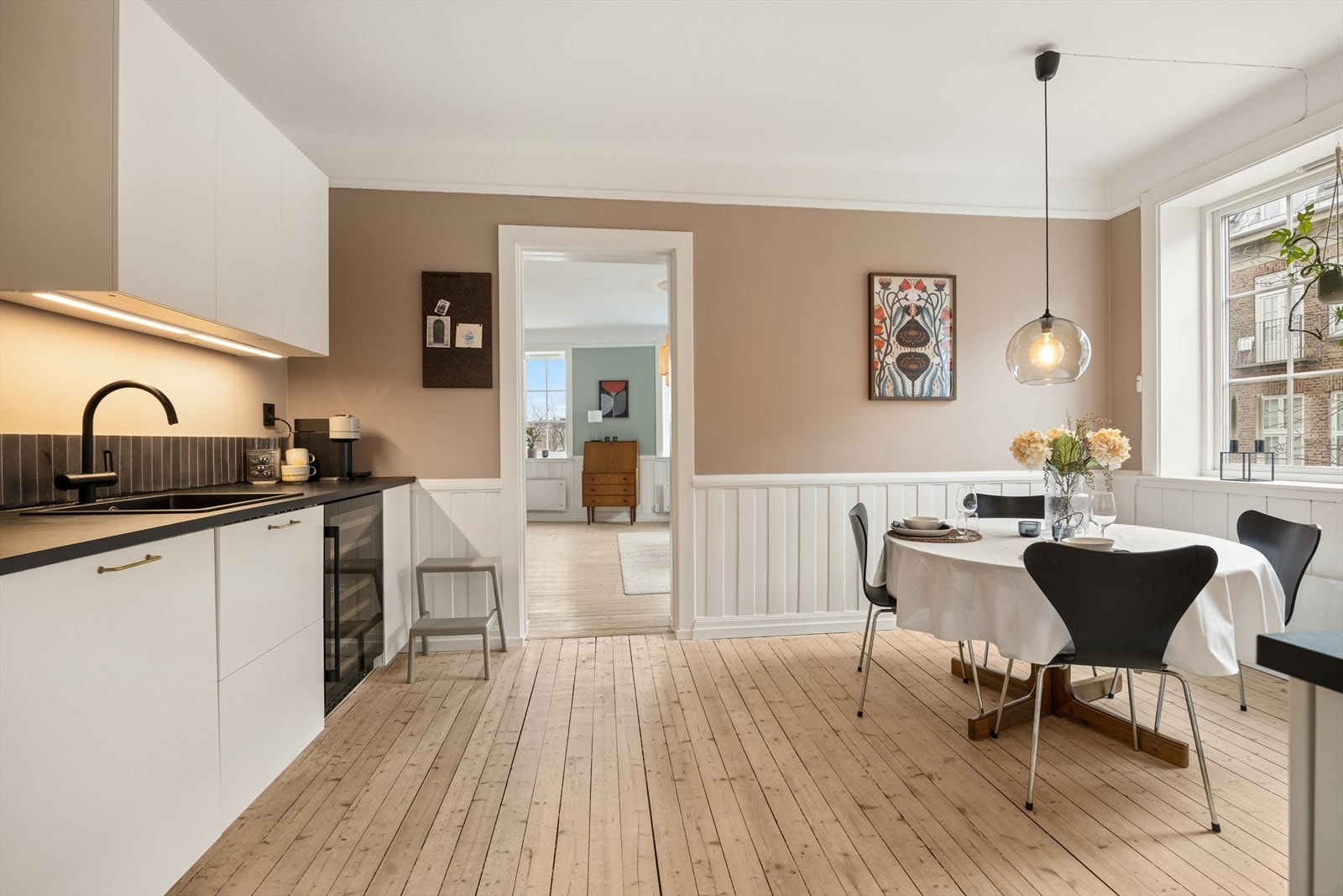 Innredningen har slette fronter og en praktisk laminatbenkeplate med fliser på veggen over. Galleribilde