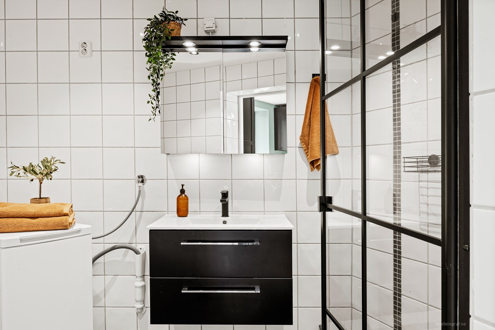 Rommet har innredning med nedfelt servant, toalett, dusjvegger/hjørne og opplegg for vaskemaskin. Galleribilde