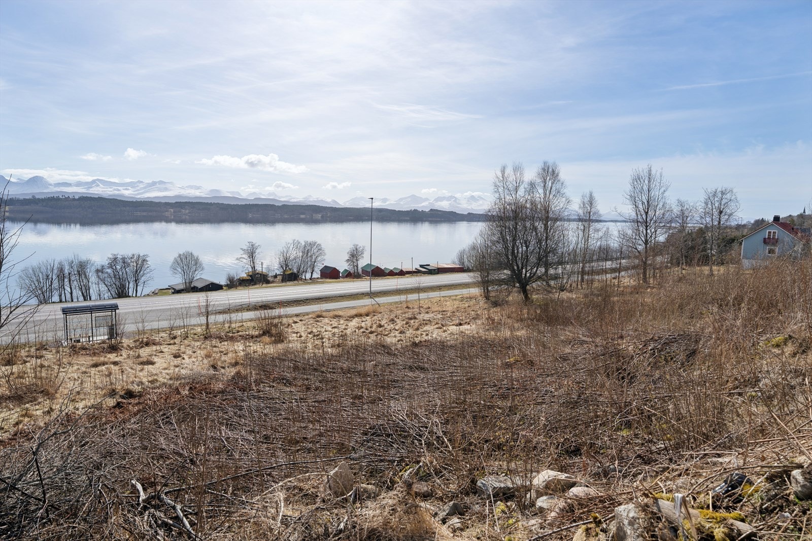 Fra tomtegrensen ser man direkte ned mot fjorden, noe som gir en umiddelbar nærhet til landskapet. Galleribilde