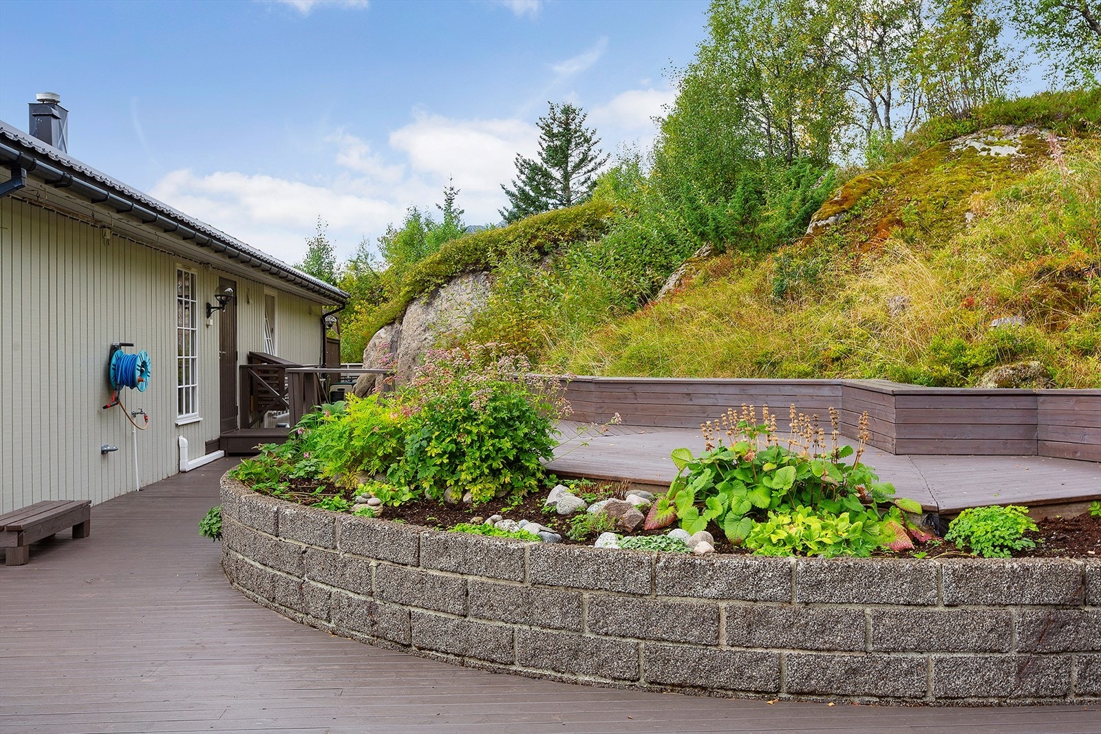 Pent opparbeidet med blomsterbed - Perfekt lekeplass på haugen Galleribilde