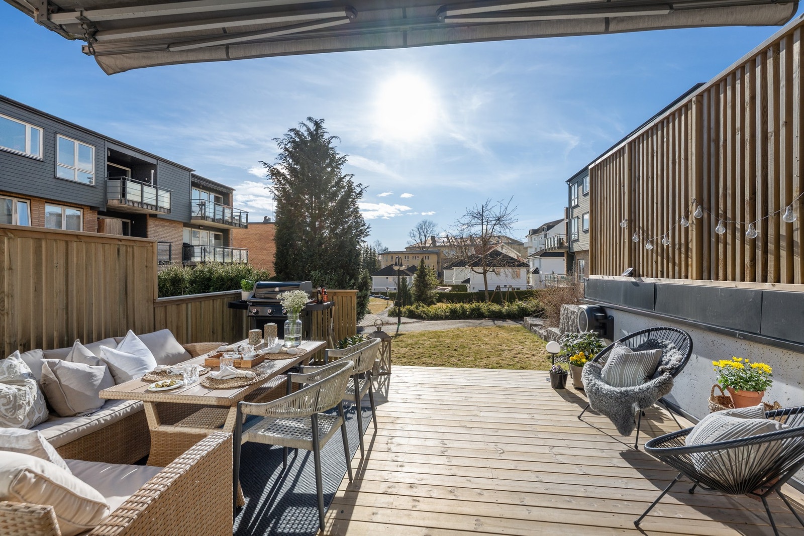 Skjermet og solrik uteplass med nyere terrassedekke og nyetablert levegg Galleribilde