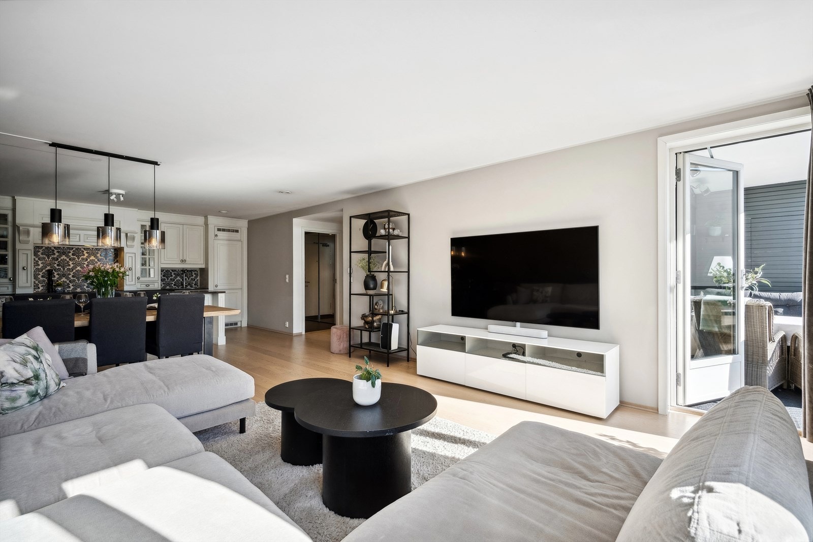 Lys og åpen stue. Overflatene er malt i lys og lun tone og det en en stavs parkett på gulv. Galleribilde