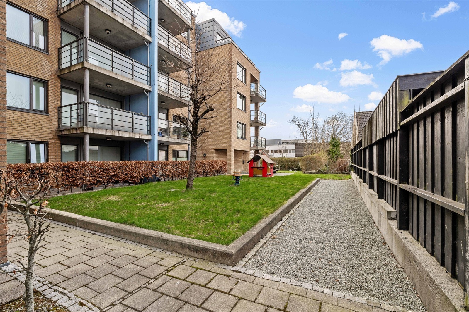 Fellesområdene er pent opparbeidet med plen, beplantning og en egen liten lekeplass. Galleribilde