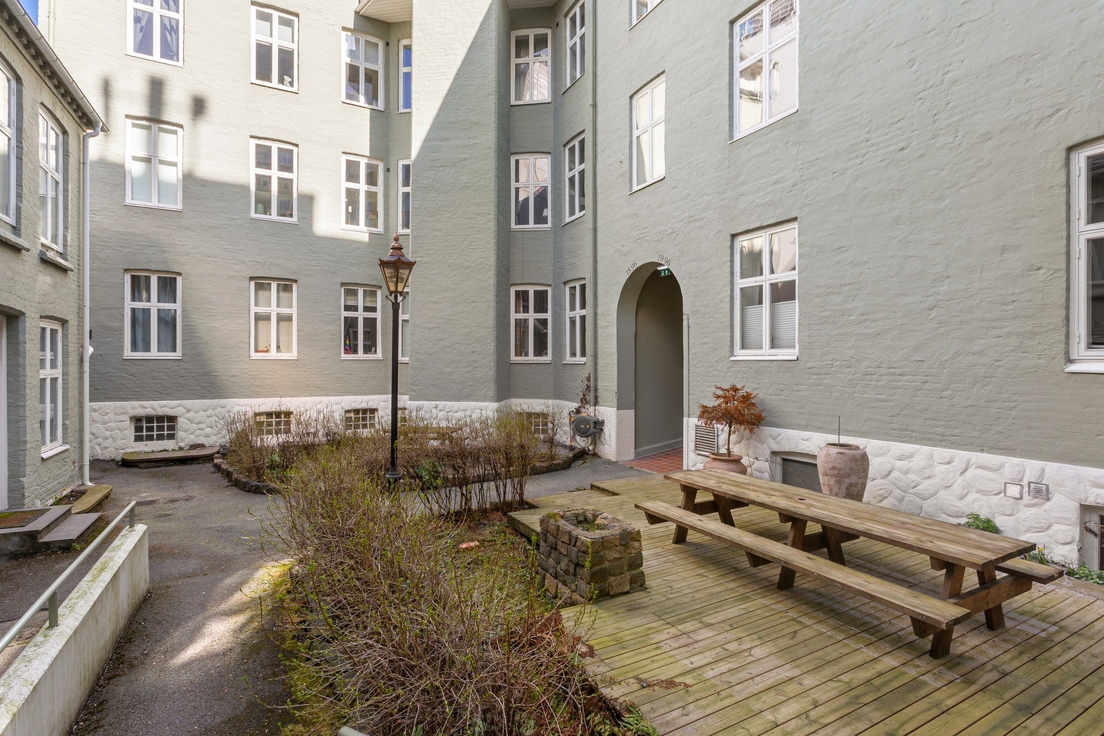 Bakgården er opparbeidet med lav hekk, felles terrasse og utemøblement, og har innmurt grill. Galleribilde