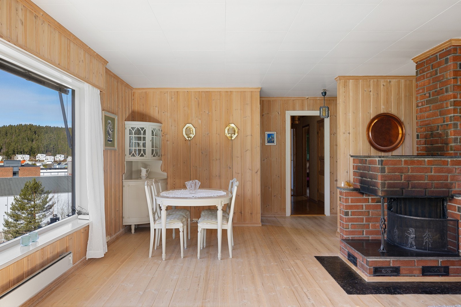 Stuen har slitesterkt tregulv og vegger kledd med panel, noe som gir rommet et varmt og tidløst preg. Galleribilde