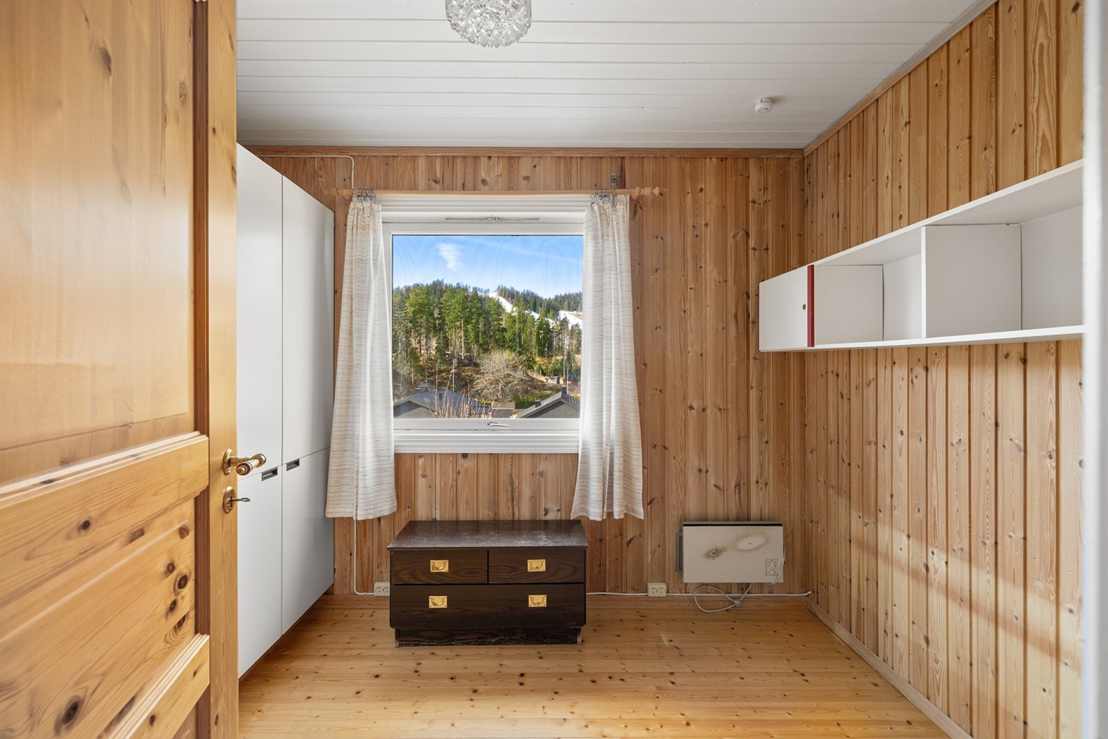 Soverom 3 - Boligen har to soverom i underetasjen med lyse gulv og panelte vegger. Galleribilde
