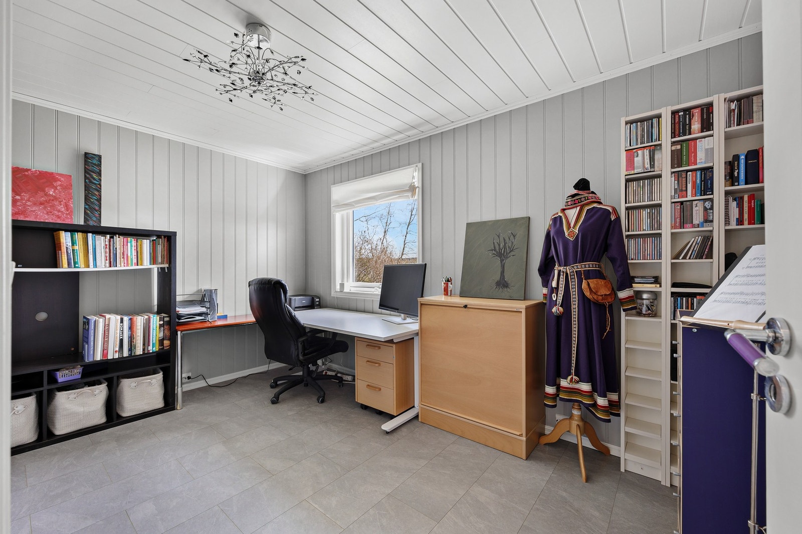 Soverom 2 benyttes av dagens eier som et praktisk kontor. Rommet har malt smartpanel på veggflater, fliser på gulv og et stort vindu. Galleribilde