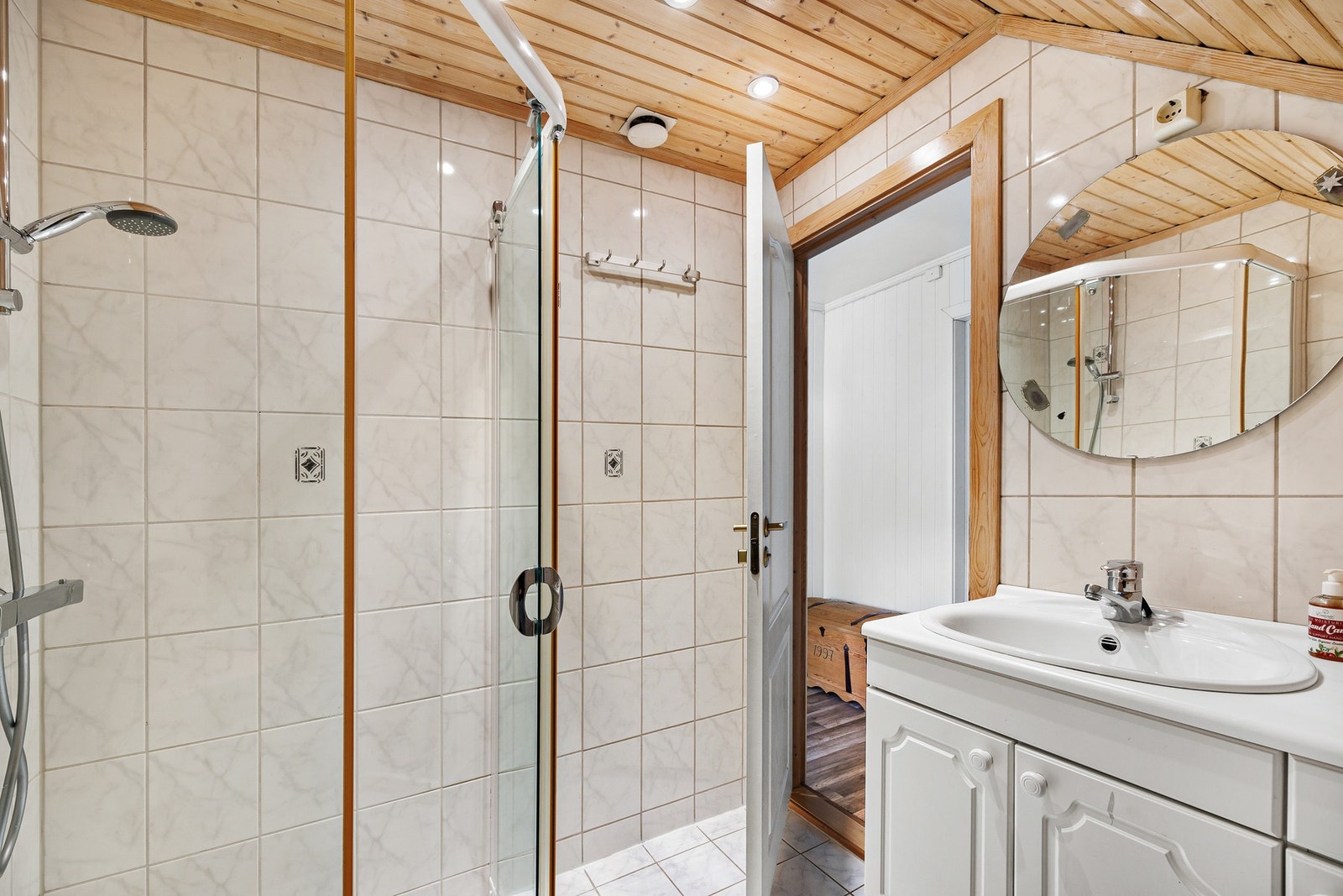 Badet i andre etasje har flislagt gulv med gulvvarme, flislagte vegger og himling med downlights. Galleribilde