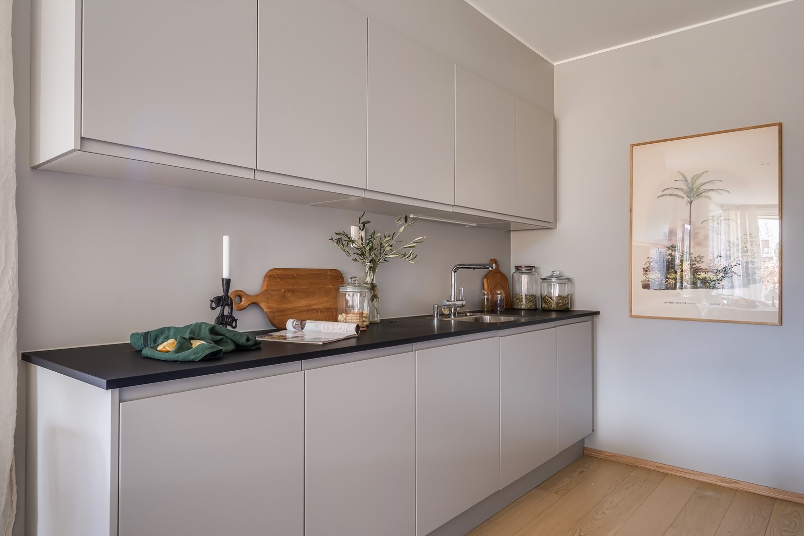 En stilren kjøkkeninnredning med slette overflater og benkeplate av laminat. Galleribilde