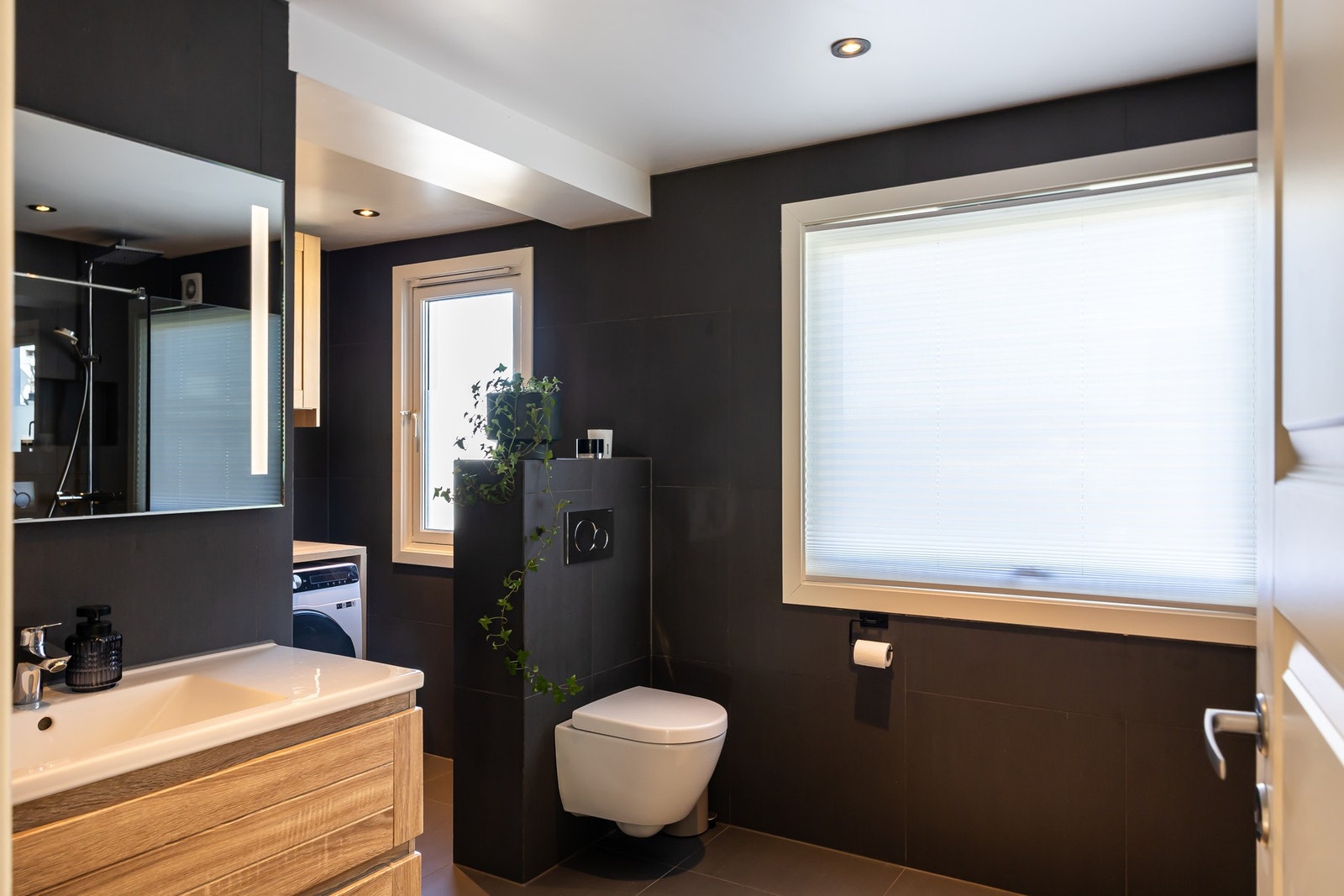 Badet er innredet med dusjløsning med glassvegger, servant med underskap, speil med integrert belysning og gode oppbevaringsmuligheter. Galleribilde