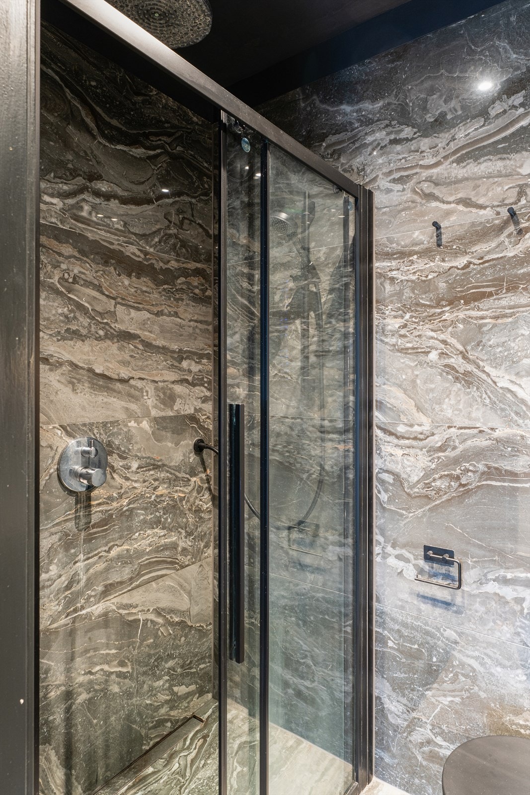 Badet har nedfelt servant, veggmontert toalett og dusjnisje med dør i herdet glass. Galleribilde