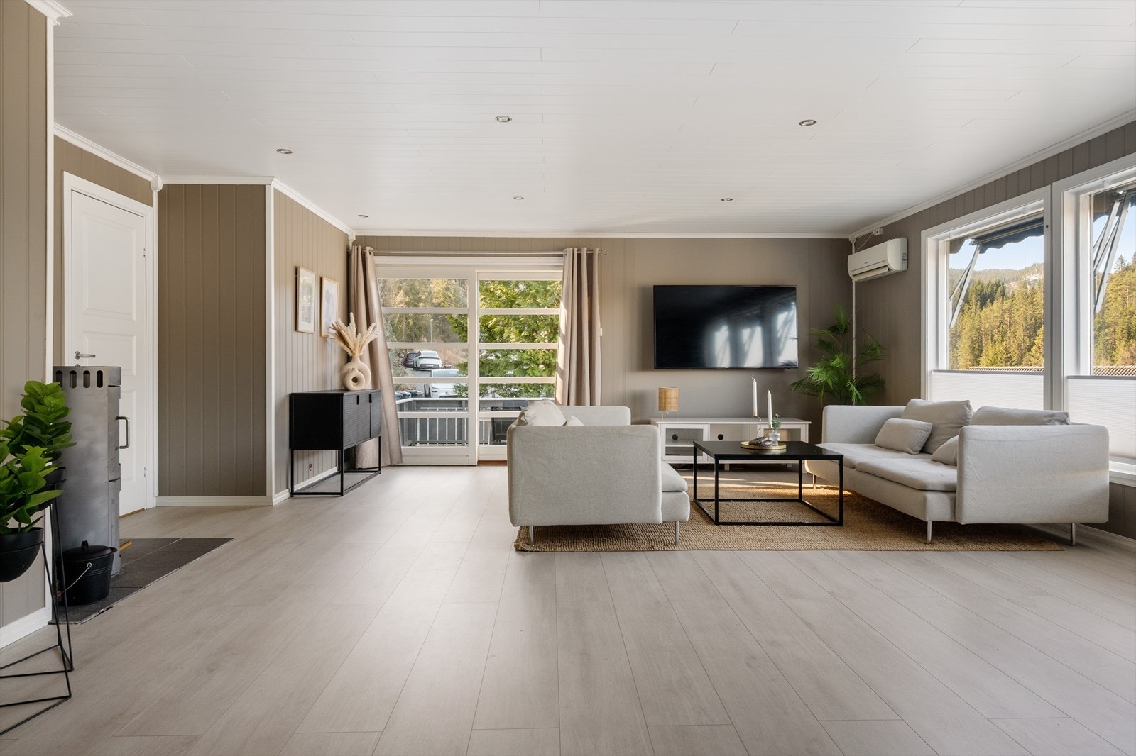 Fin fargepalett på vegger og laminat fra 2020 på gulvet. I stuen er varmekildene elektrisk, vedovn og varmepumpe. Galleribilde