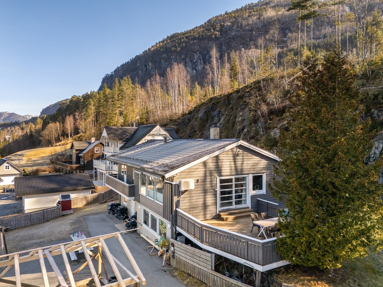 Uterom som består av overbygget altan, terrasse, hageflekk på baksiden og flere parkeringsplasser i eget tun. Galleribilde