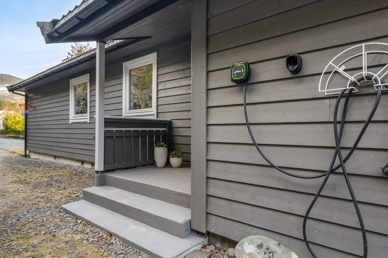 Det er montert elbil-lader på utsiden av boligen. Galleribilde
