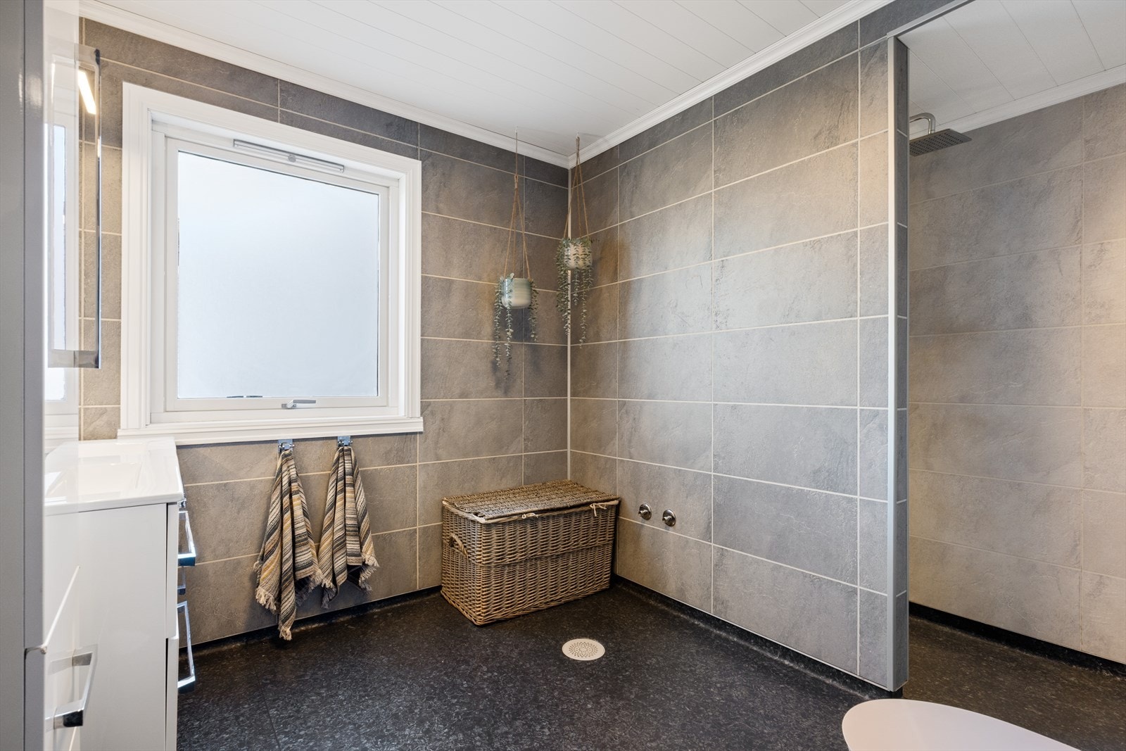 Vinylbelegg på gulv, baderomsplater på vegger og malt panel i tak. Galleribilde