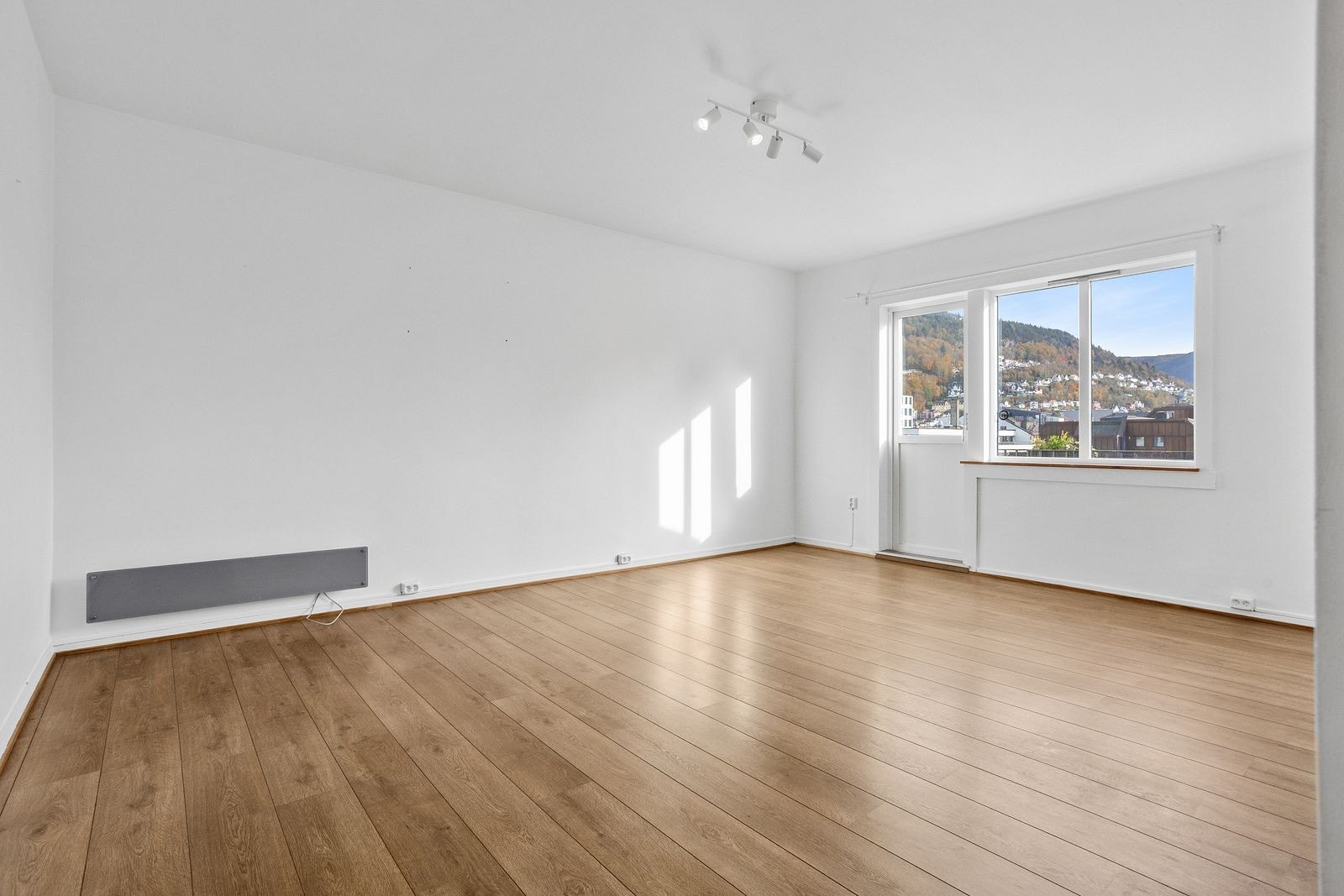 Lys og romslig stue, hvor det er plass til både sofakrok og spisebord. Galleribilde