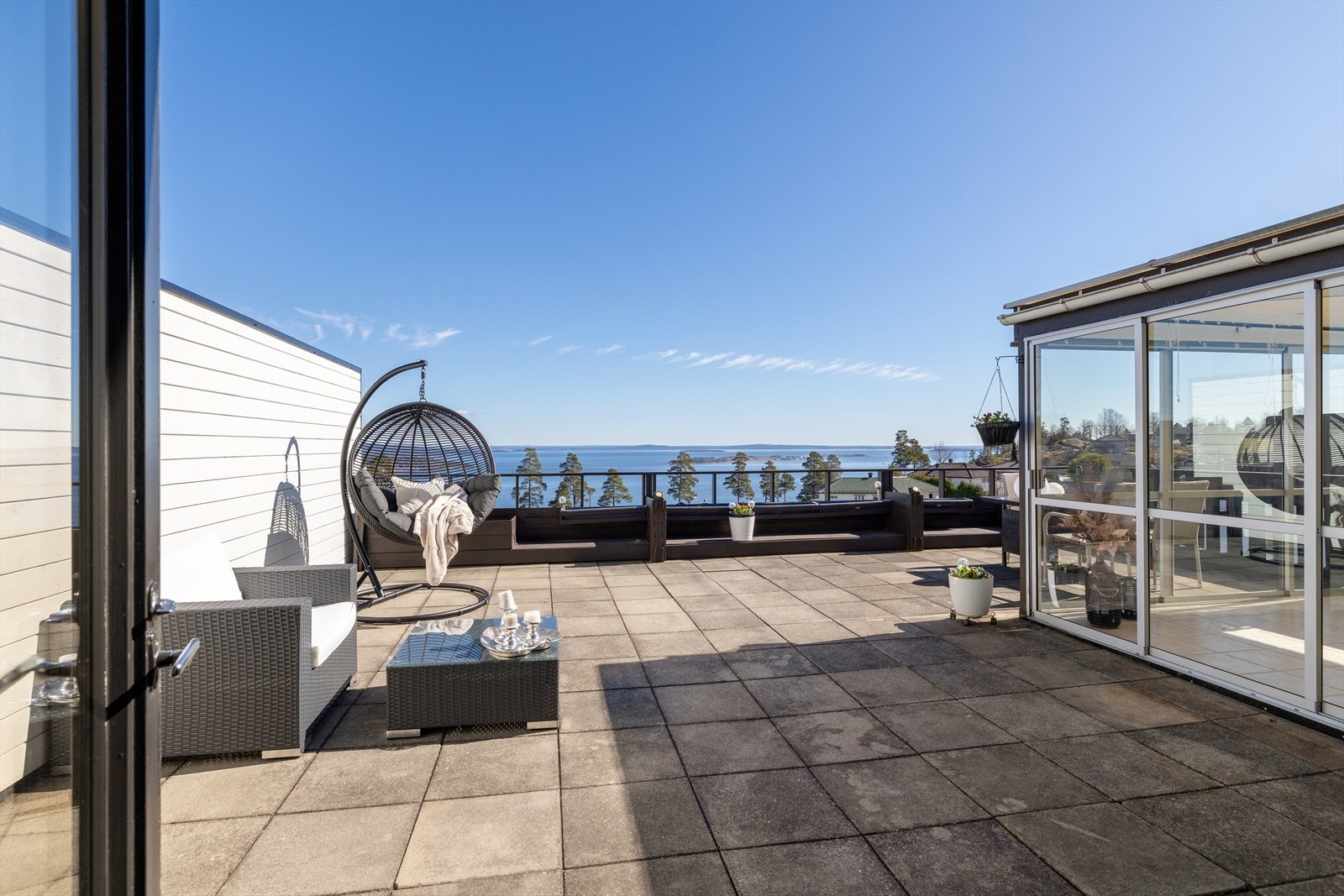 Terrassen har god plass til flere sittegrupper og er lagt med betongheller. Det tette sjiktet under ble fornyet i 2019. Galleribilde