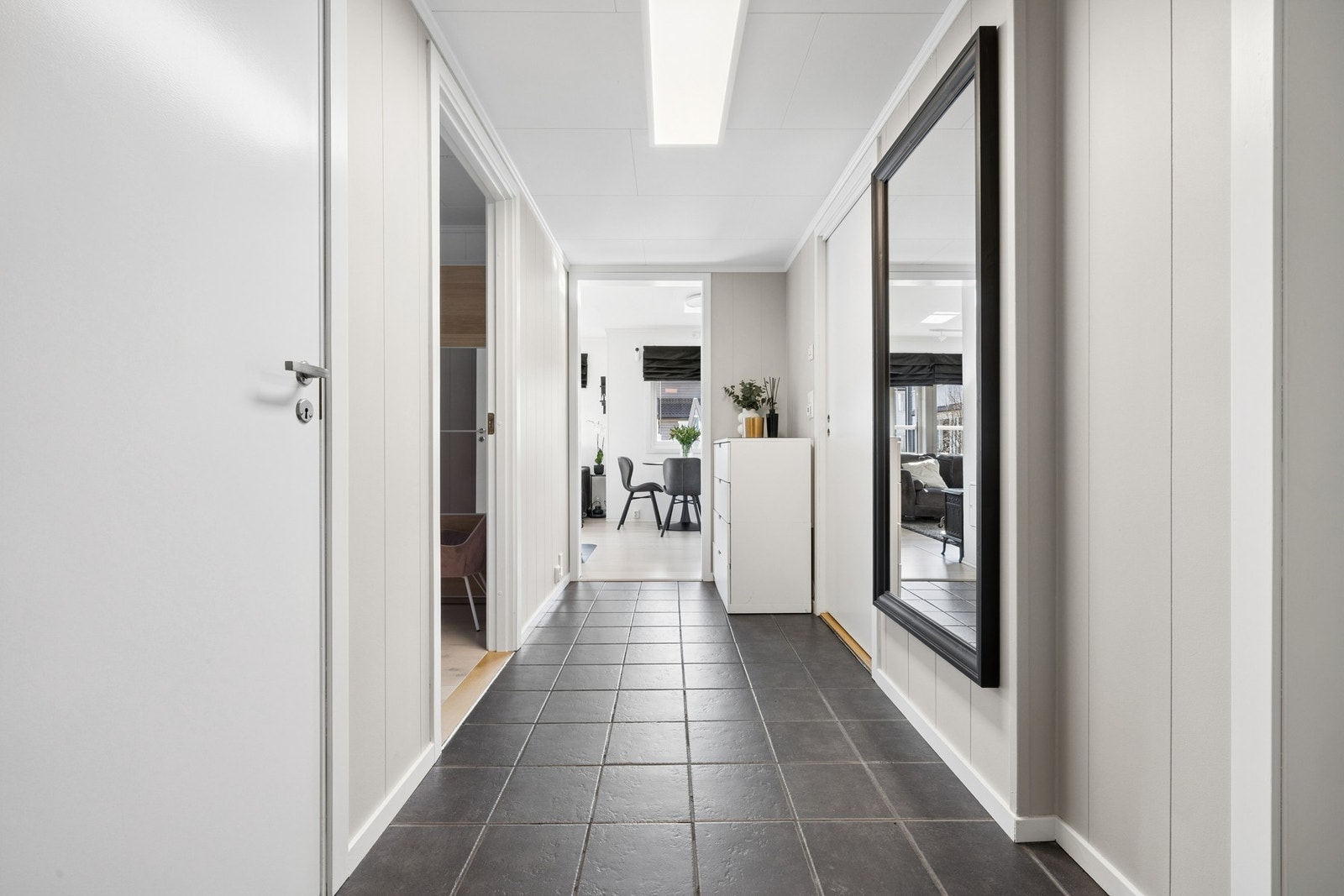 Boligen ønsker deg velkommen inn i en romslig flislagt gang/entré. Her er det mulighet for kommodeløsning for oppbevaring og en praktisk bod. Galleribilde