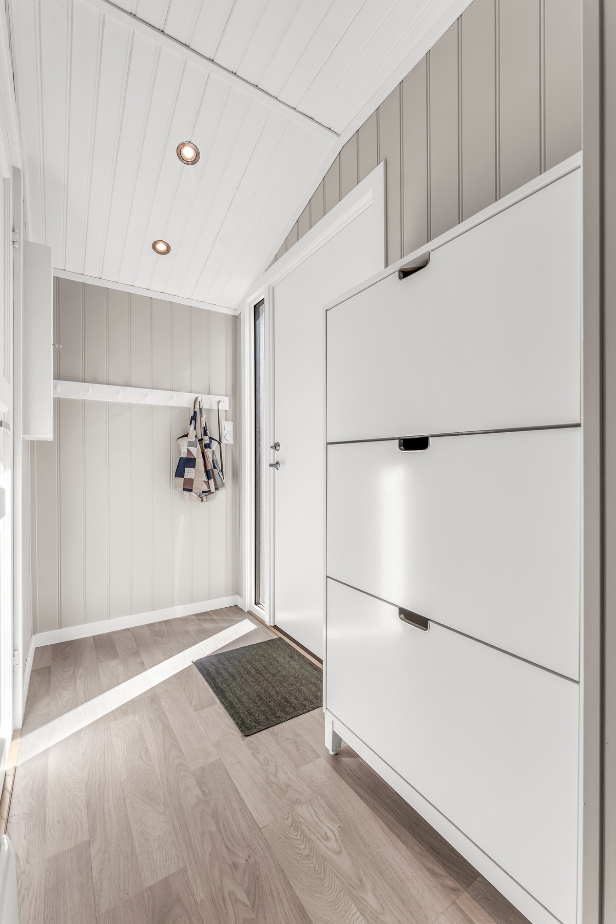 Lyst og hyggelig entrè med oppheng for yttertøyet Galleribilde