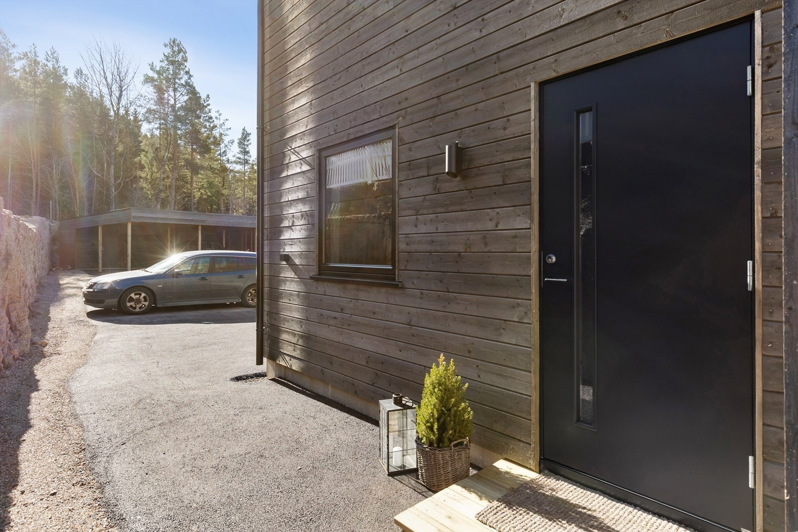 Asfaltert gårdsplass fører frem til en solid, malt hovedytterdør. Galleribilde