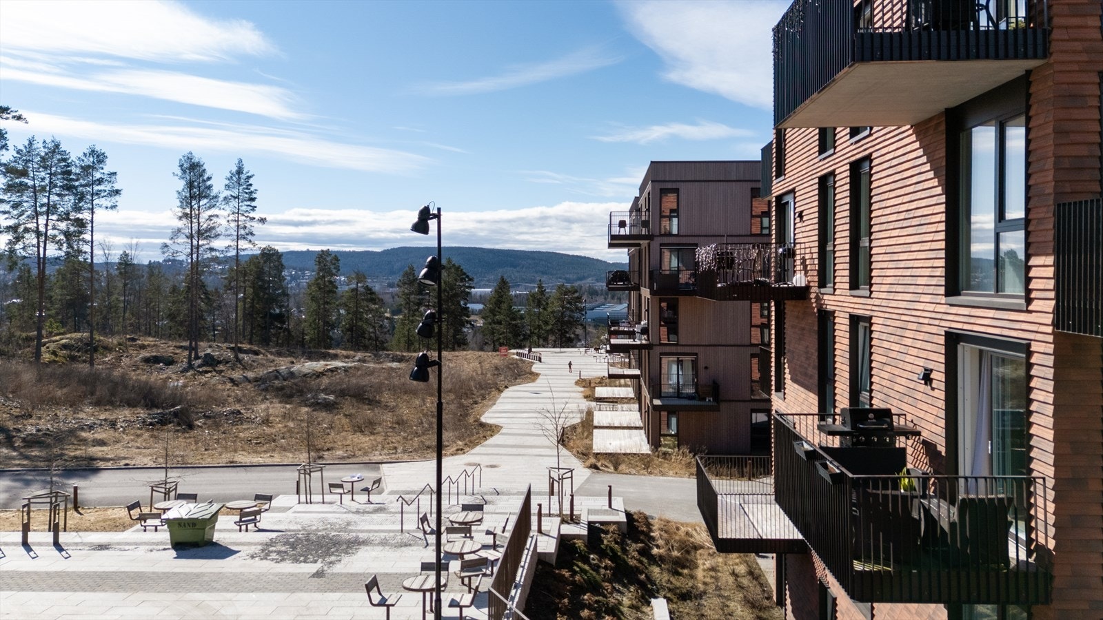 Pent opparbeidede fellesarealer med sittegrupper og gangstier. Galleribilde