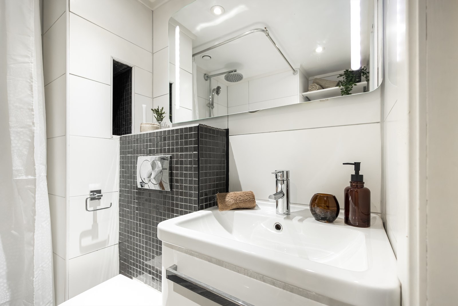 Vegghengt toalett og en kompakt servantinnredning bidrar til en god utnyttelse av arealet på badet. Galleribilde