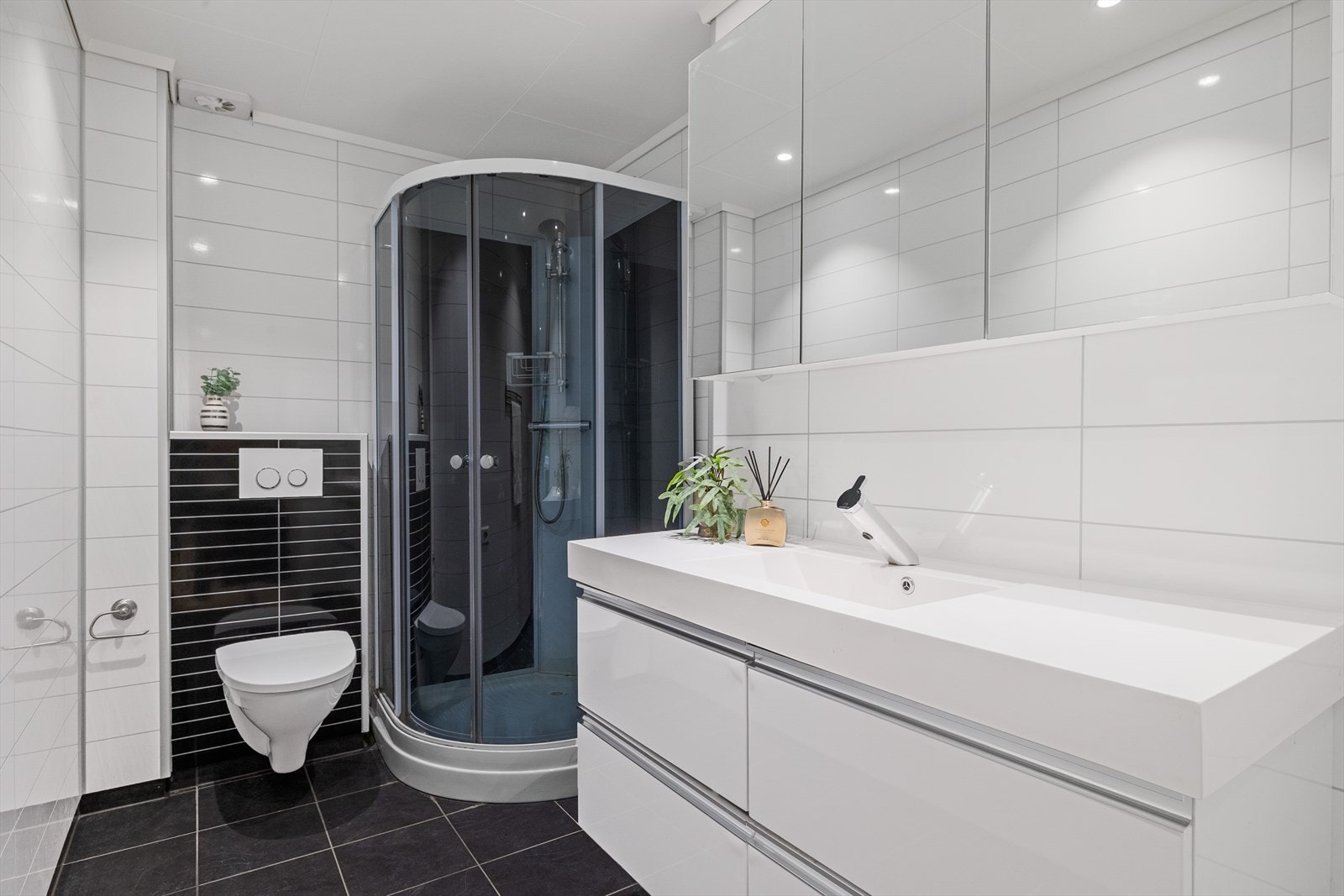 Baderomsplater på vegger og malte himlingsplater. Det er innredet med dusjkabinett, servant og veggmontert wc. Badet er fra 2014. Galleribilde
