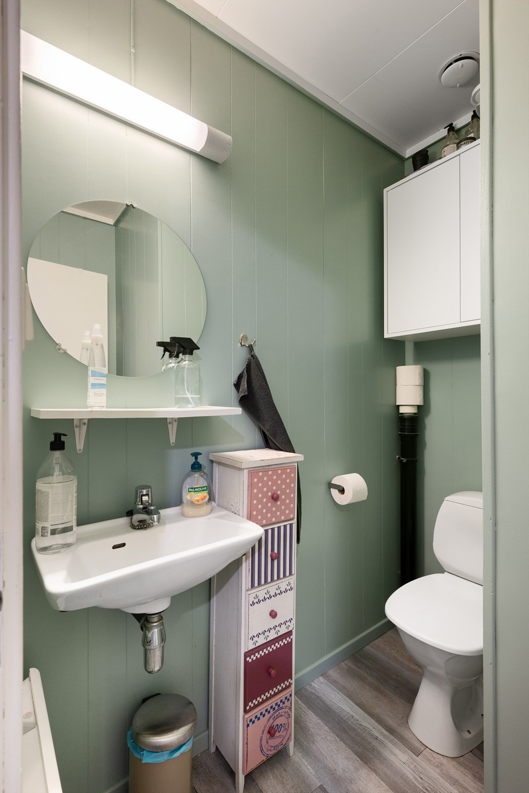 Baderom som er innredet med toalett, servant og speil. Galleribilde