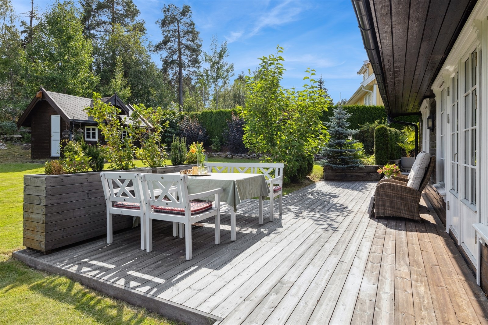Uteområdet er pent opparbeidet med plen, hekk og beplantning som rammer inn eiendommen. Galleribilde