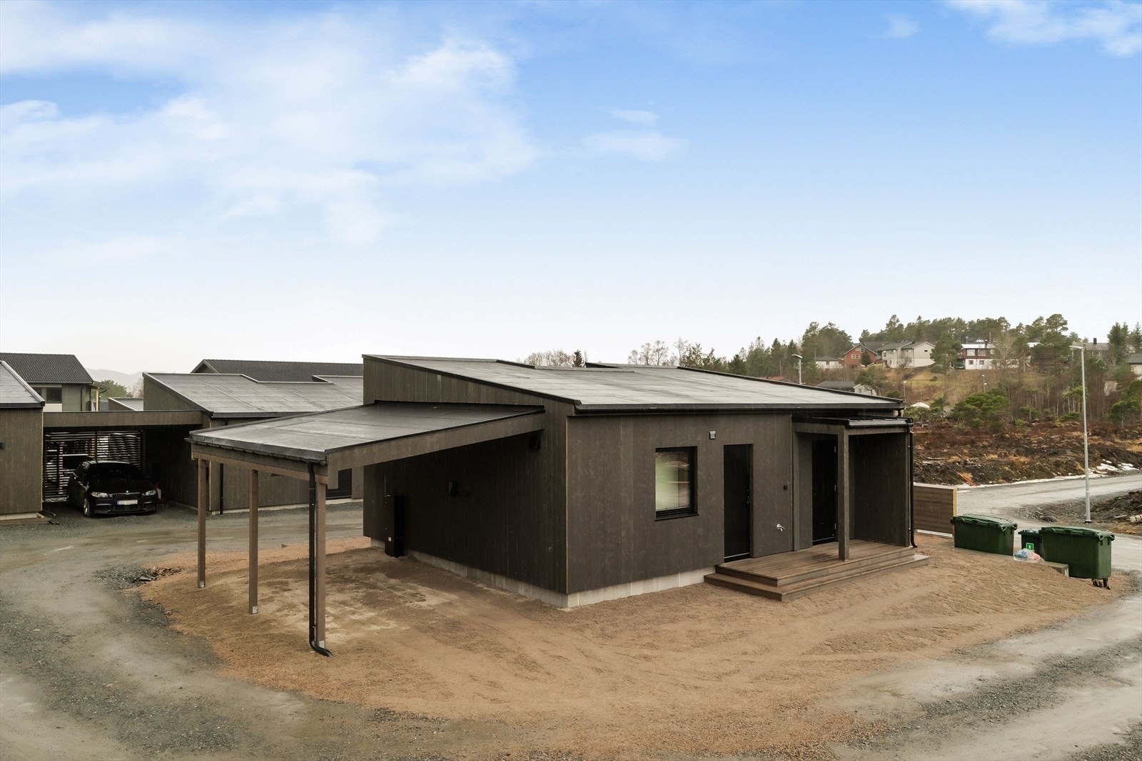 Det er montert el-billader i carport. Det vil også bli asfaltert vei i området. Galleribilde