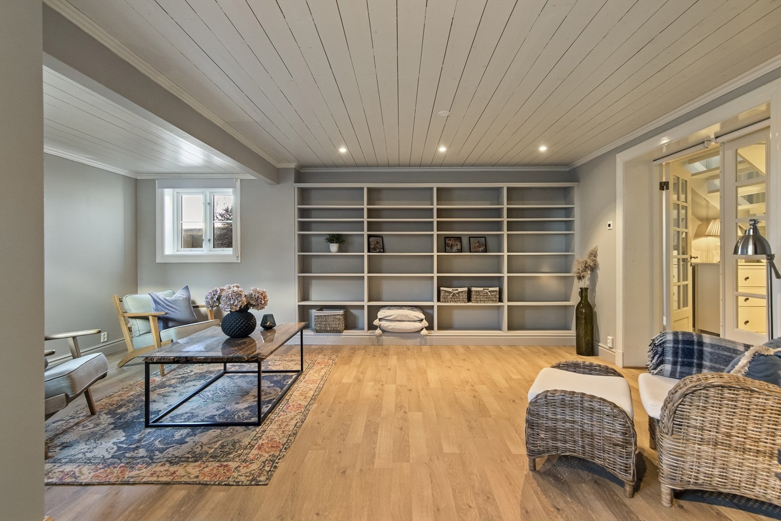 I kjelleretasjen har boligen et stort, innredet rom i bruk som stue. Rommet har downlights, en utsmykket støpejernsovn og en stor, plassbygd hylleløsning - perfekt for bøker og dekor. Det gjøres oppmerksom på at rommet ikke er godkjent for varig opphold. Galleribilde