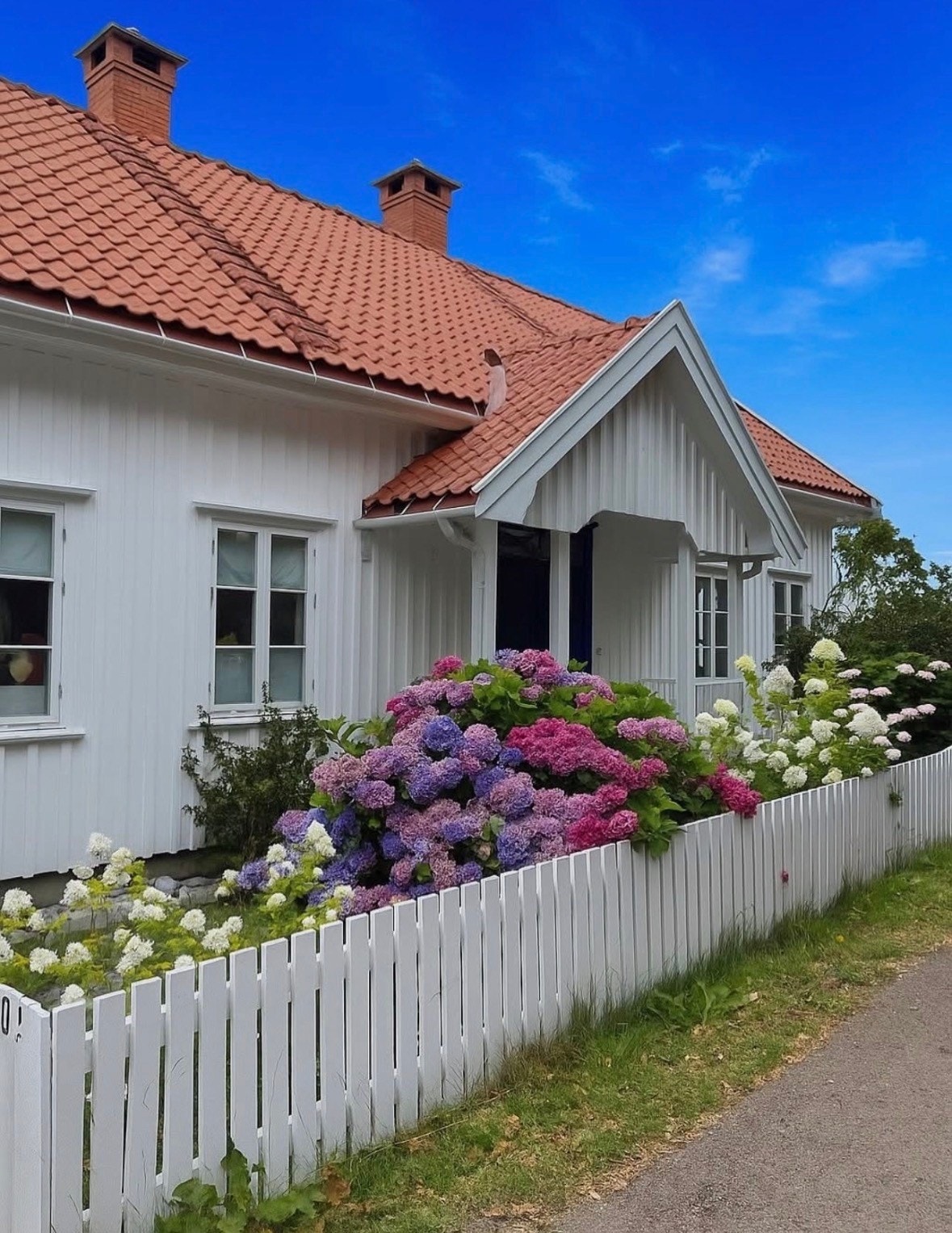 Hagen fremstår som en vakker og idyllisk oase, pent opparbeidet med frodig plen og rik beplantning. Her kan man glede seg over et variert blomsterflor gjennom sesongen, med blant annet vakre pioner, romantiske roser og en stor og frodig hortensia. Galleribilde