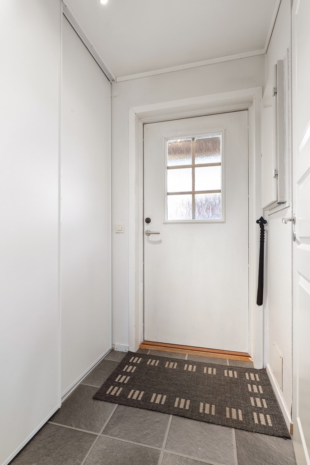 Praktisk entré med flislagt gulv. Entréen har skyvedørsgarderobe med gode oppbevaringsmuligheter for sko- og yttertøy. Sikringsskapet er plassert her. Galleribilde