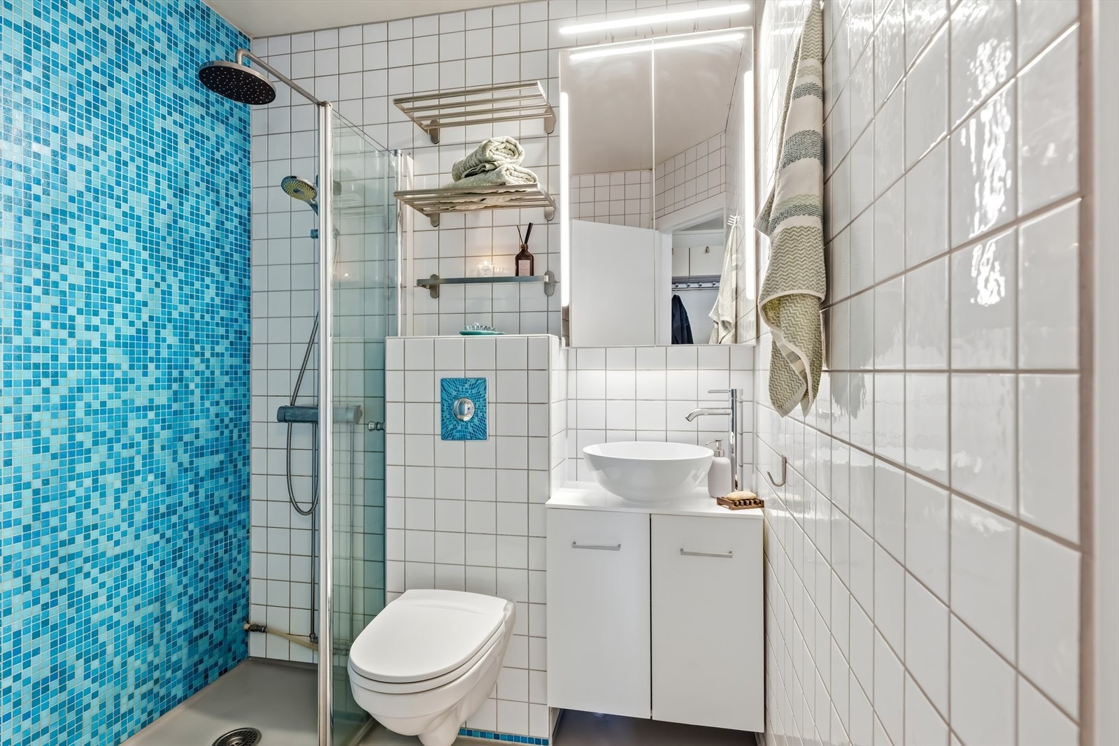 Badet er utført med flislagte vegger og gulv med vinylbelegg. Her finner du vegghengt toalett, dusjhjørne og baderomsinnredning. Det er oppvarming med panelovn. Galleribilde