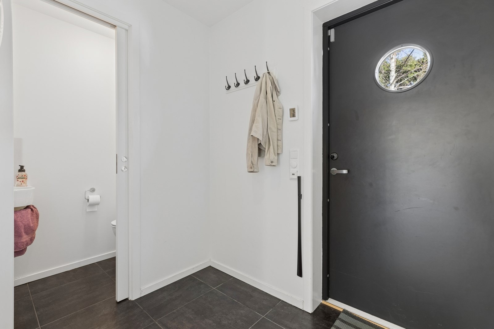 Innbydende inngangspartiet med gjestetoalett og knagger til yttertøy. Galleribilde