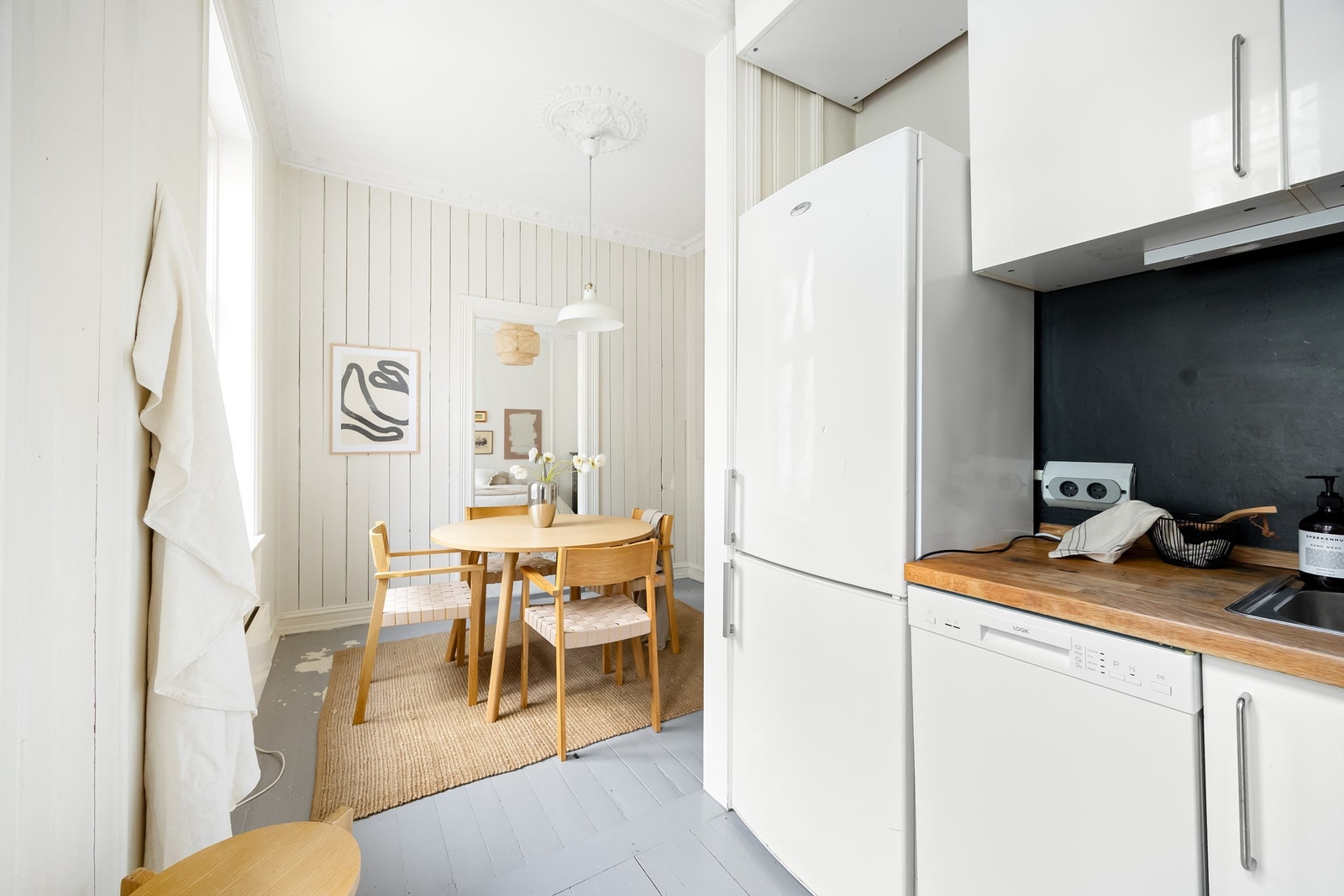Kjøkkenet er utstyrt med integrerte hvitevarer som induksjonsplatetopp i benkeplaten, stekeovn og 45cm oppvaskmaskin, samt frittstående kjøleskap med fryser. Galleribilde