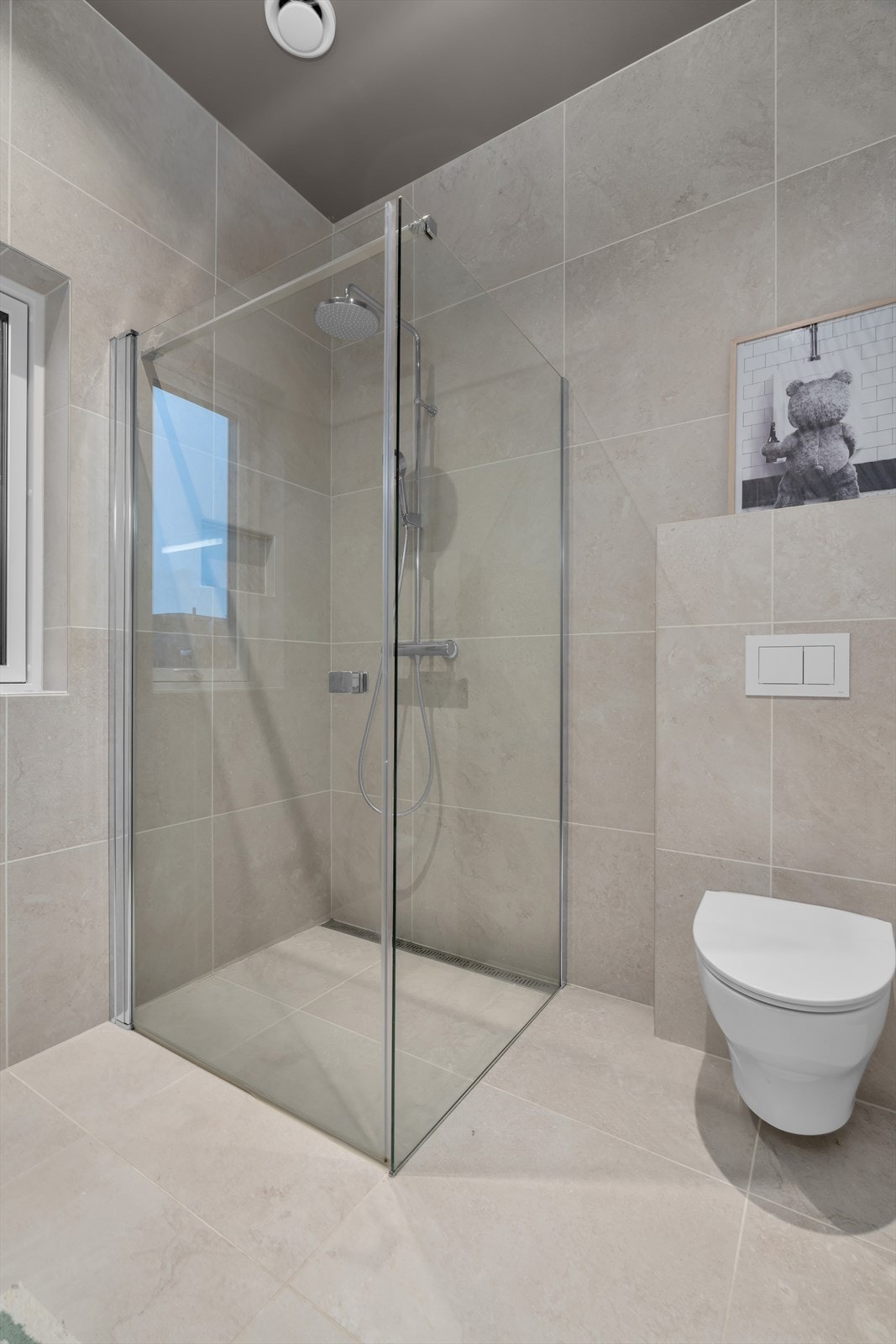 Badet er stilfullt innredet med en stor innredning med skuffer som gir rikelig med oppbevaringsplass, et speil med belysning samt et vegghengt toalett. Dusjnisjen er godt plassert og gir en romslig og moderne løsning. Galleribilde