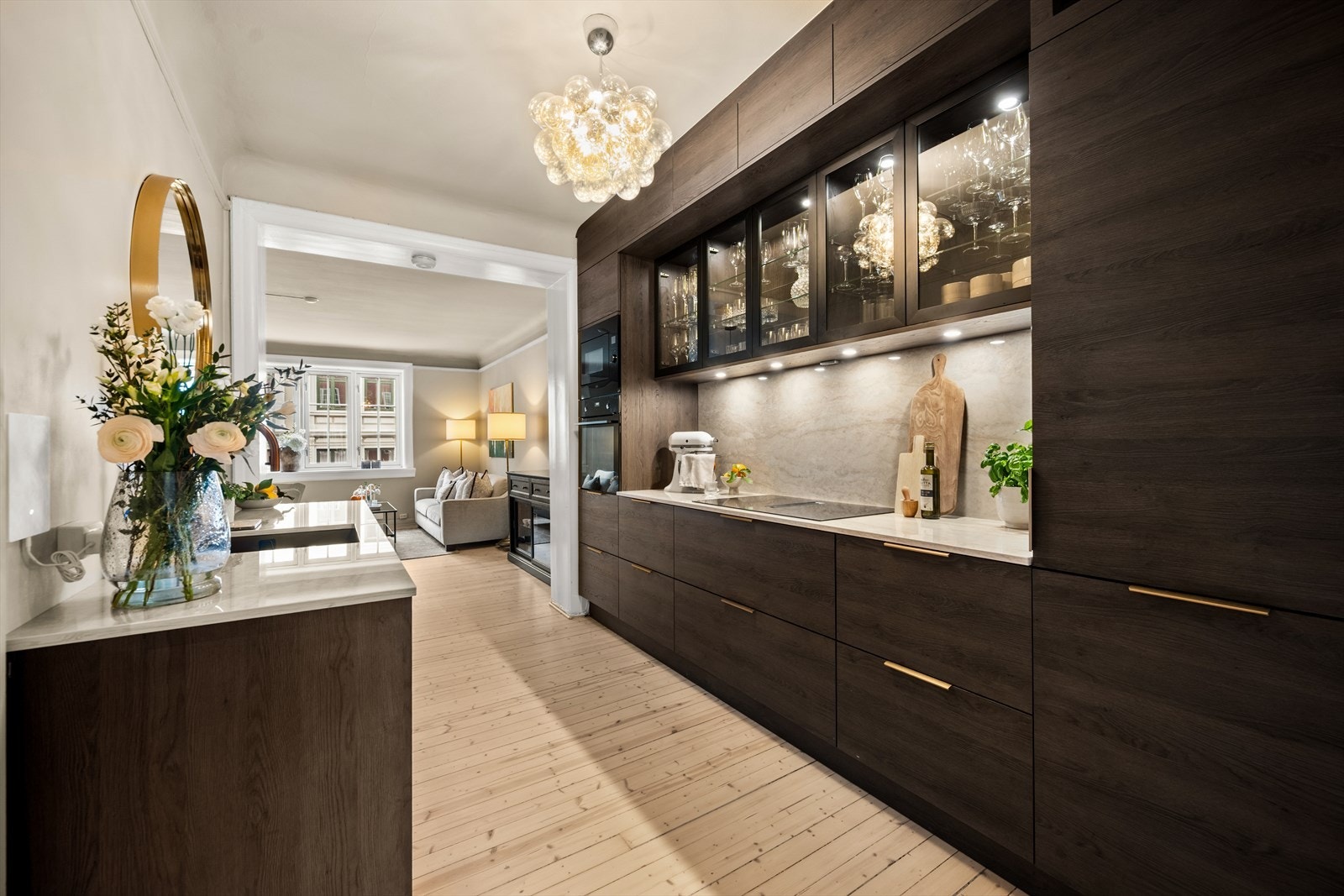 Den rålekre kjøkkeninnredningen er fra Strai med glatte fronter i mørk brun, enkelte overskap med glassfronter og Dekton benkeplate. Galleribilde