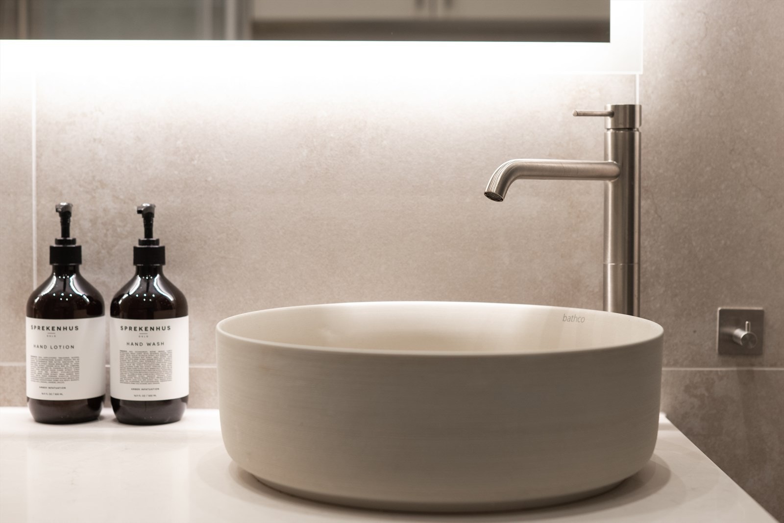Badet er innredet med dusjhjørne med innfellbare glassdører, vegghengt toalett og moderne baderomsinnredning med bollevask, stort speil og blandebatteri. Blandebatteri, dusj og flere detaljer i brushed nickel fra Tapwell. Galleribilde