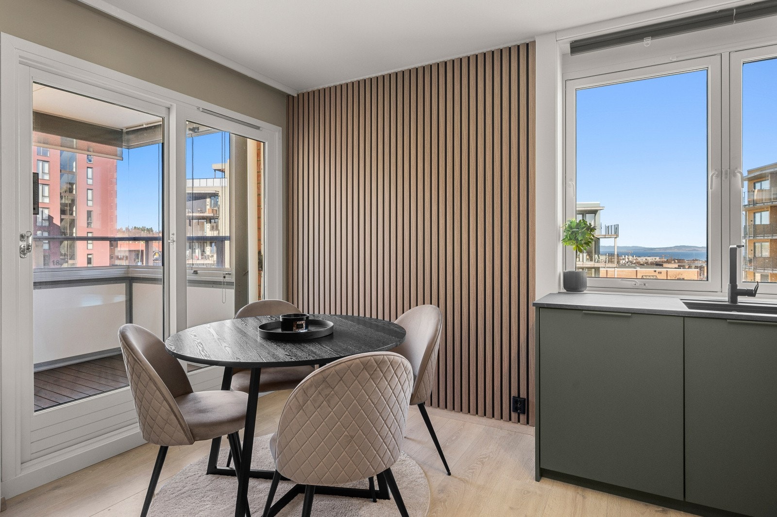 Spiseplassen er rammet inn av en stilren spilevegg. Vinduene i leiligheten er fra 2017. Galleribilde