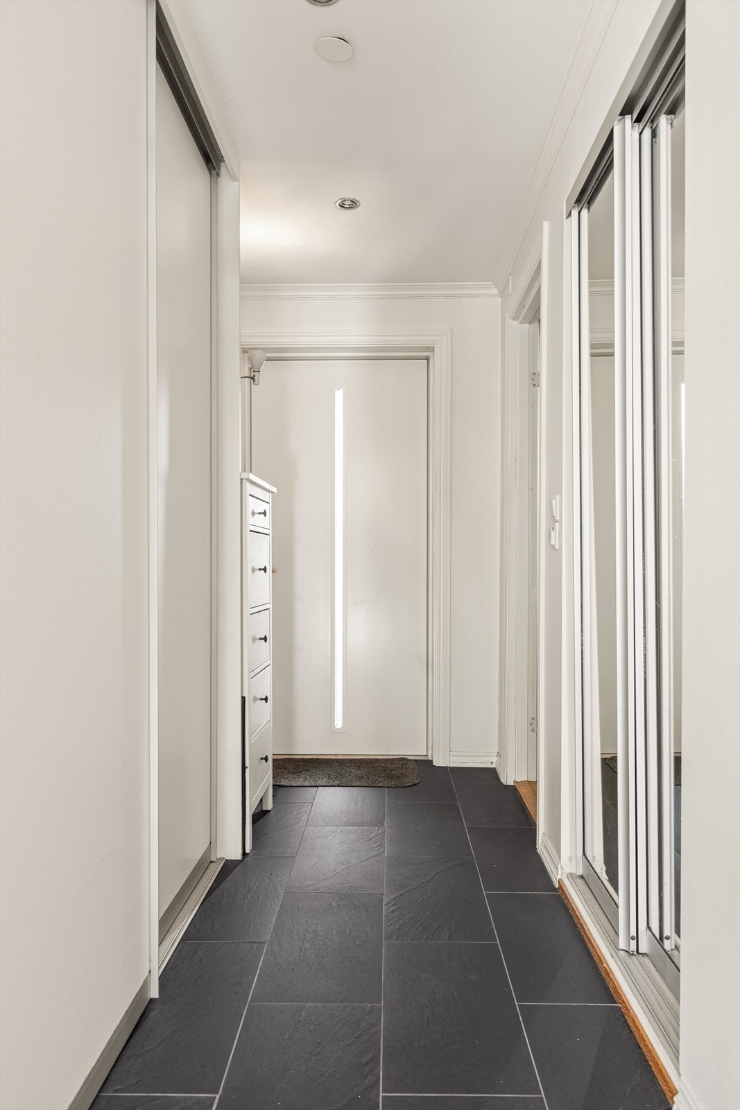 Entréen er innredet med skyvedørsgarerobe og har fliser på gulvet. Galleribilde