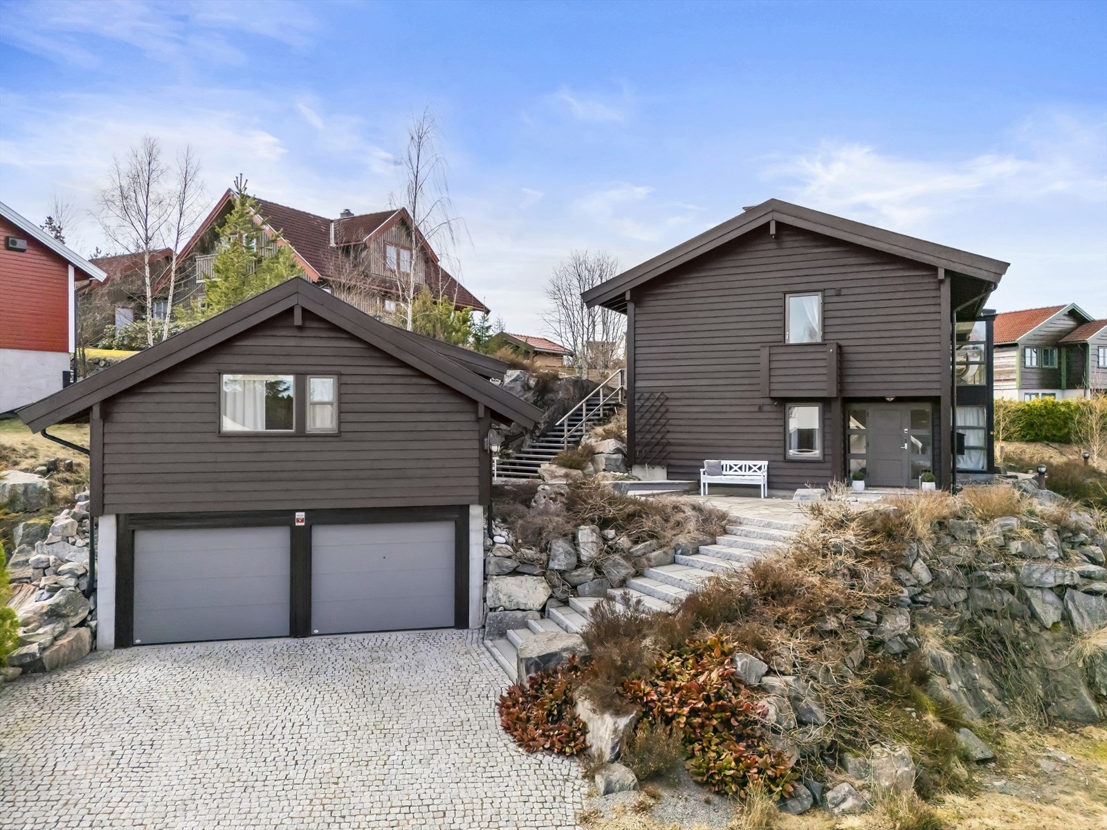 Eiendommen har en romslig gårdsplass med belegningsstein, dobbelgarasje med to ladebokser og innredet loft samt en utebod. Galleribilde