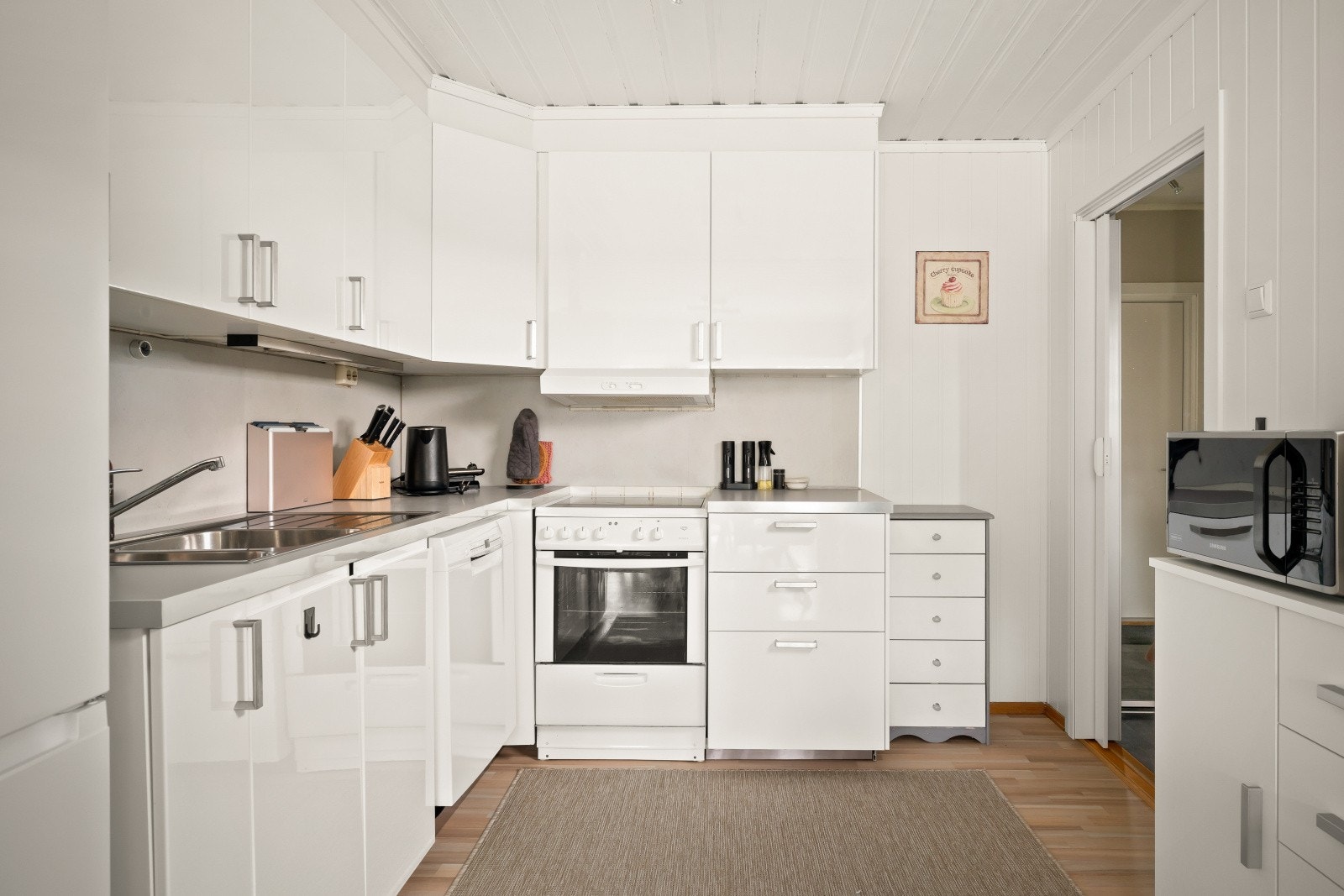 Kjøkken utleiedel har en innredning med glatte fronter og benkeplater i laminat. Galleribilde