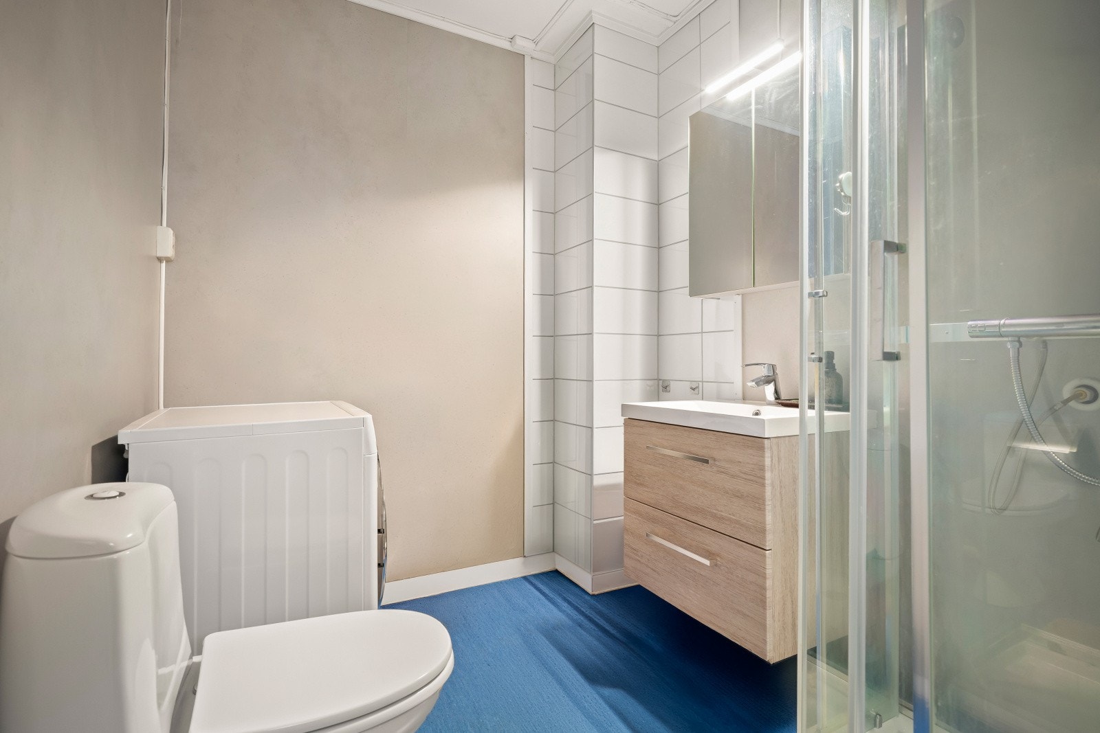 Bad/vaskerom utleiedel er innredet med en nedfelt servant, toalett, dusjkabinett og har opplegg for vaskemaskin. Galleribilde