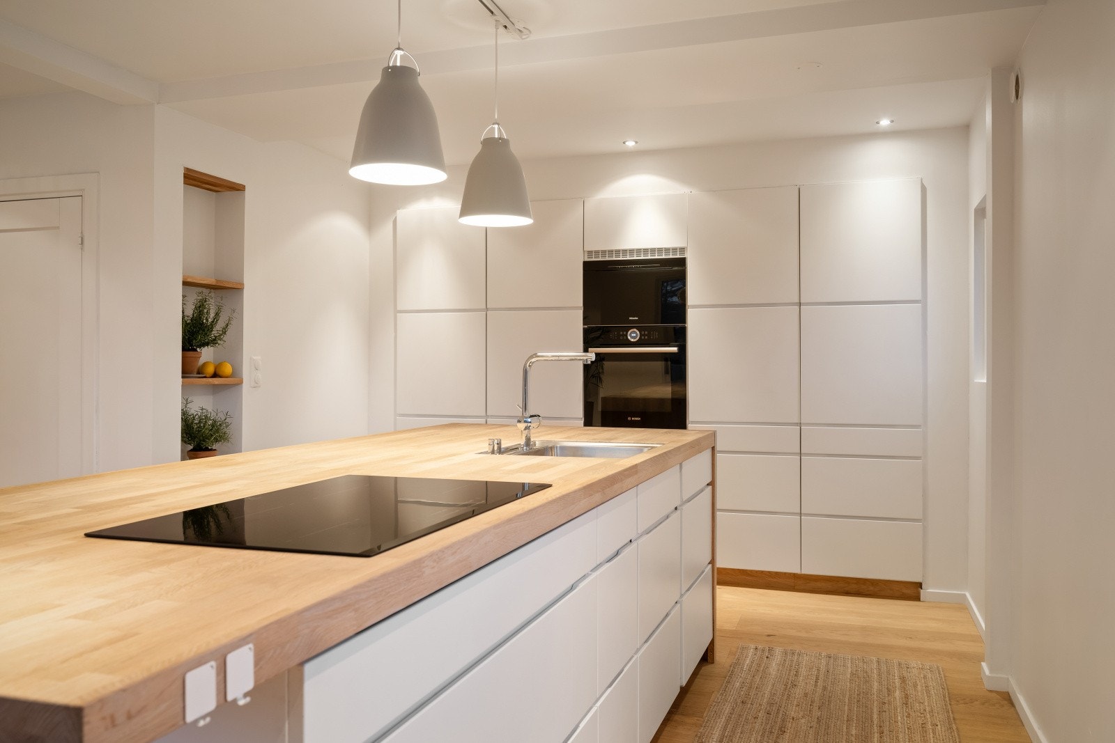 Kjøkkenet har glatte fronter og benkeplater av heltre eik, samt integrerte hvitevarer. Galleribilde