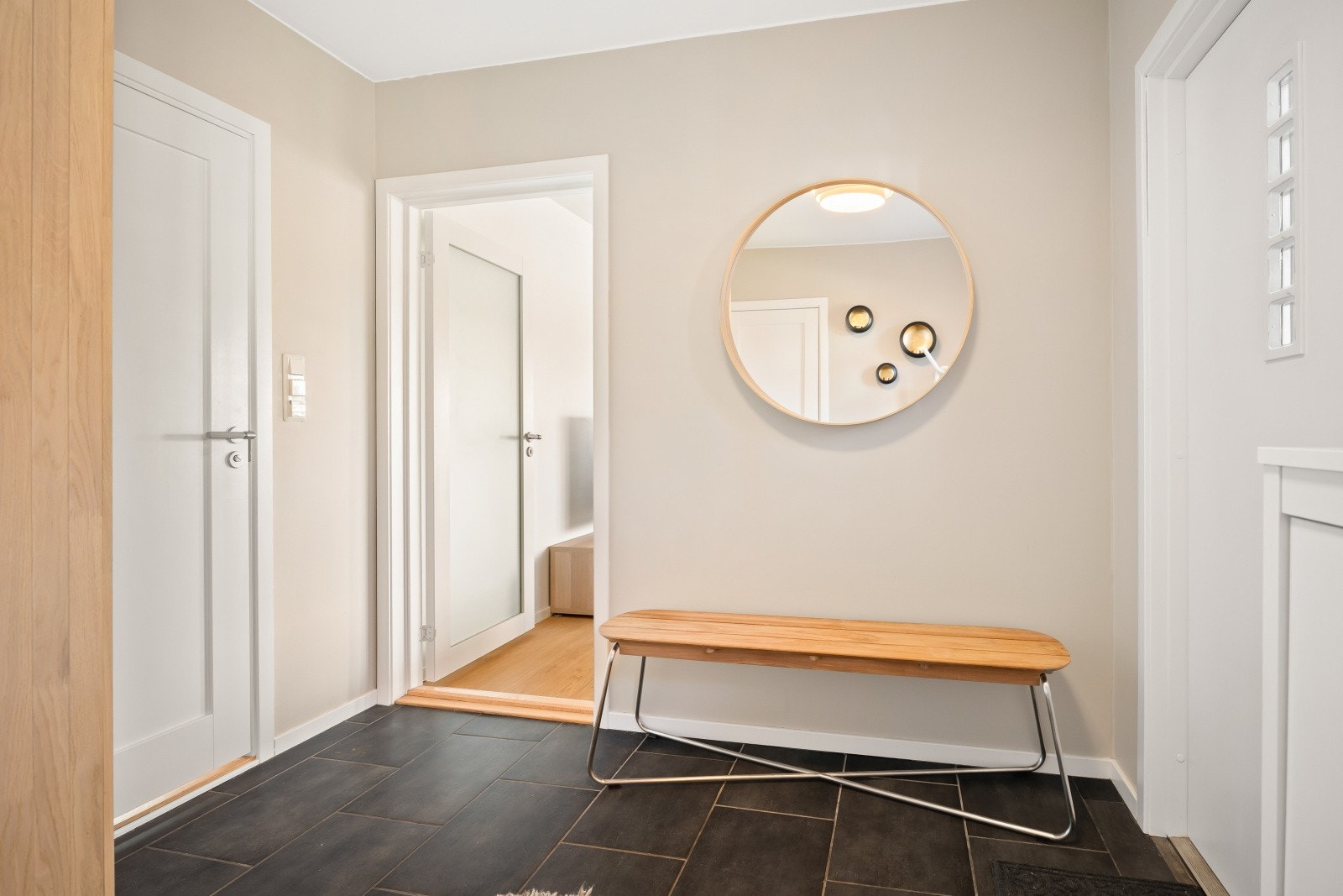 Fra gangen leder en dør med frostet glass inn til stue og kjøkken. Galleribilde