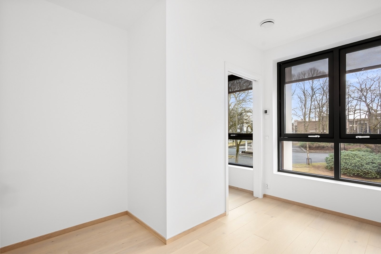 Flere store vindusflater slipper inn rikelig med naturlig dagslys og mot syd er det utsyn mot opparbeidet sentrumspark med paviljong og skøytebane om vinteren. Galleribilde