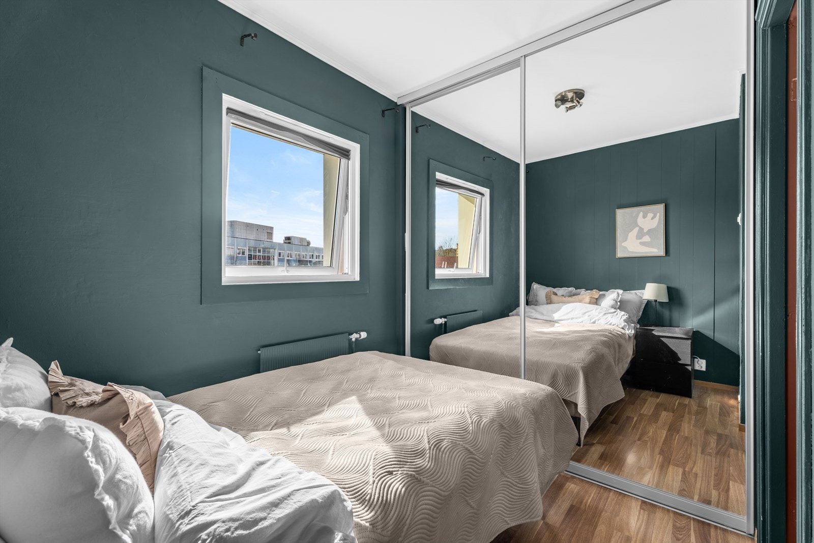 En stor skyvedørsgarderobe med speilfronter gir rikelig med oppbevaringsplass. Galleribilde