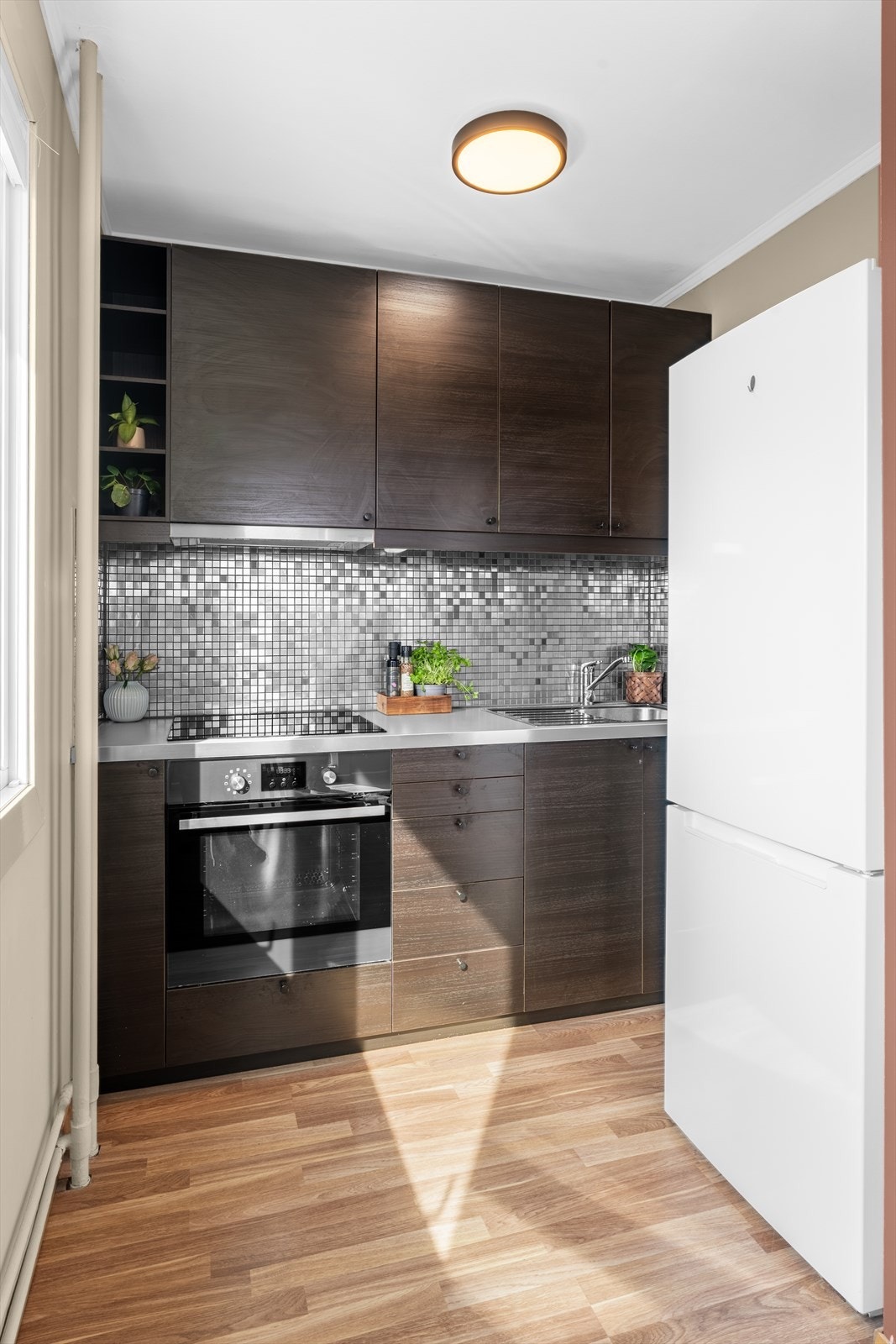 Kjøkkenet har en innredning fra Ikea med glatte, folierte fronter og benkeplate i laminat. Galleribilde
