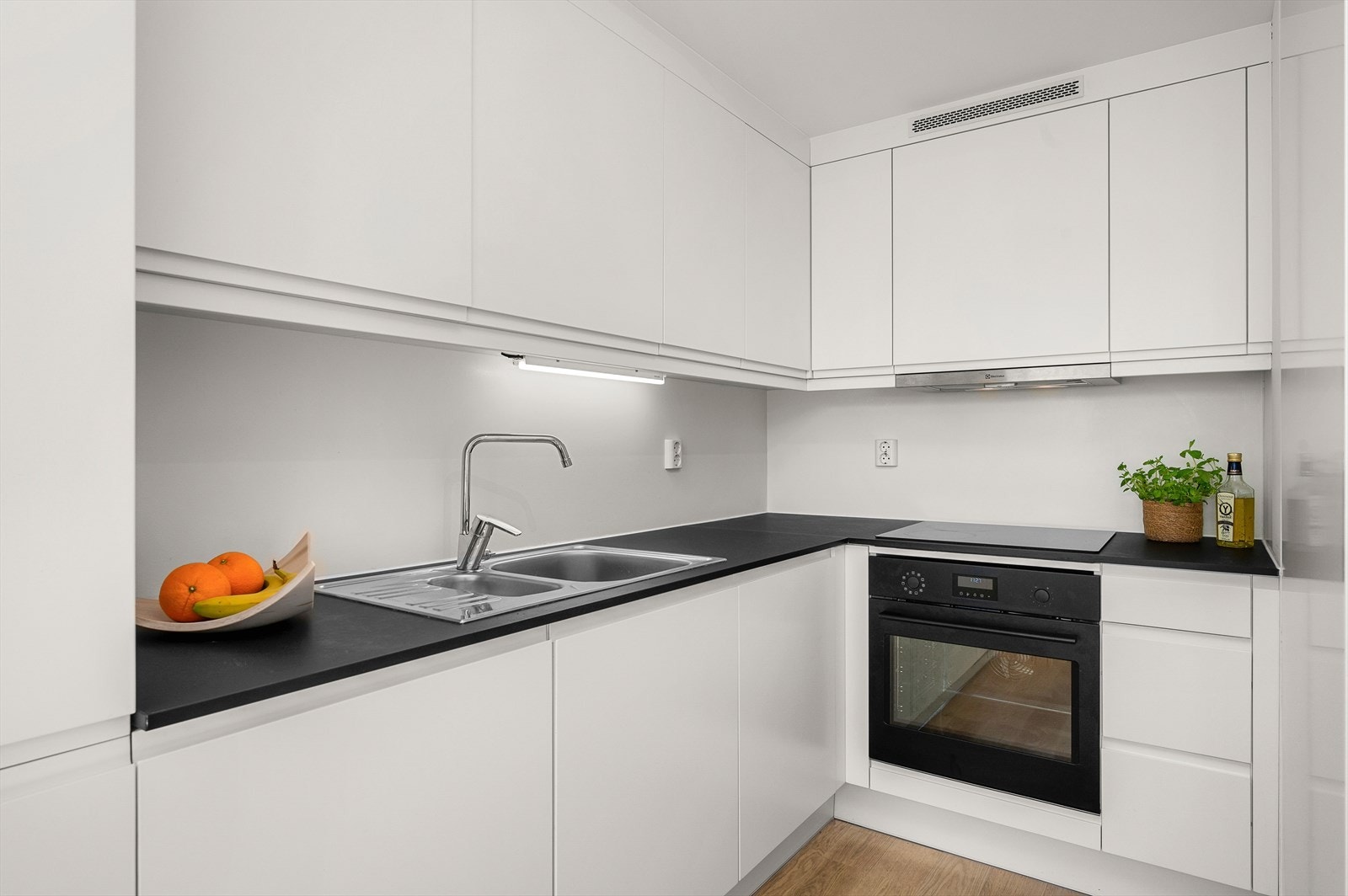 Stilrent og godt utnyttet hjørnekjøkken. Kjøkkenet byr på integrerte hvitevarer som oppvaskmaskin, kombiskap (kjøl og frys), komfyr, platetopp og ventilator. Galleribilde